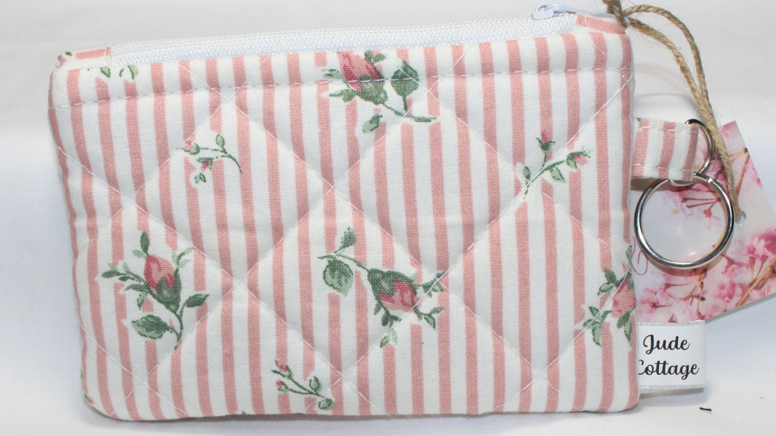 Quilted keychain wallet with Victorian floral pattern, zipper closure, and metal key ring.