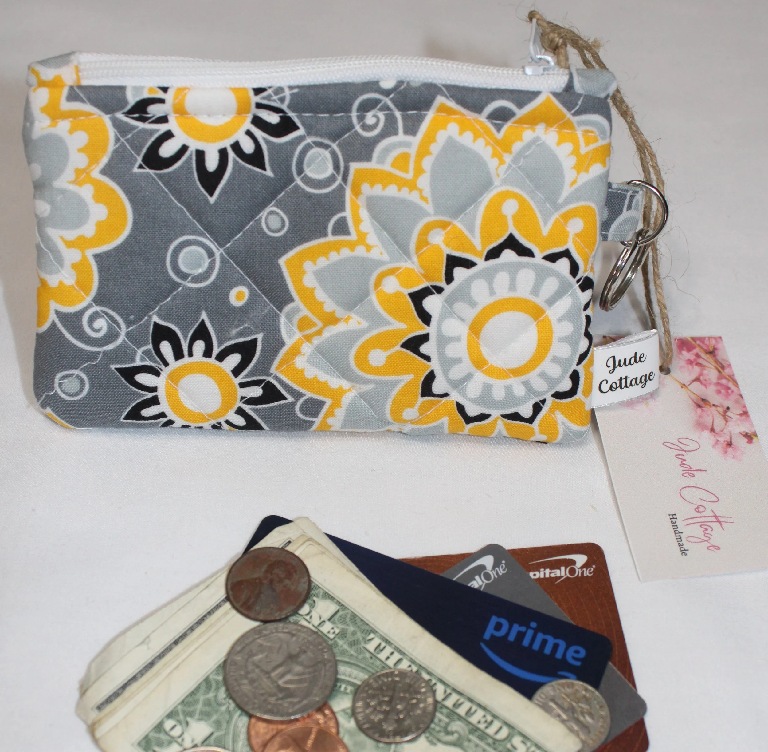 Quilted keychain wallet with medallion pattern, zipper closure, and metal key ring.