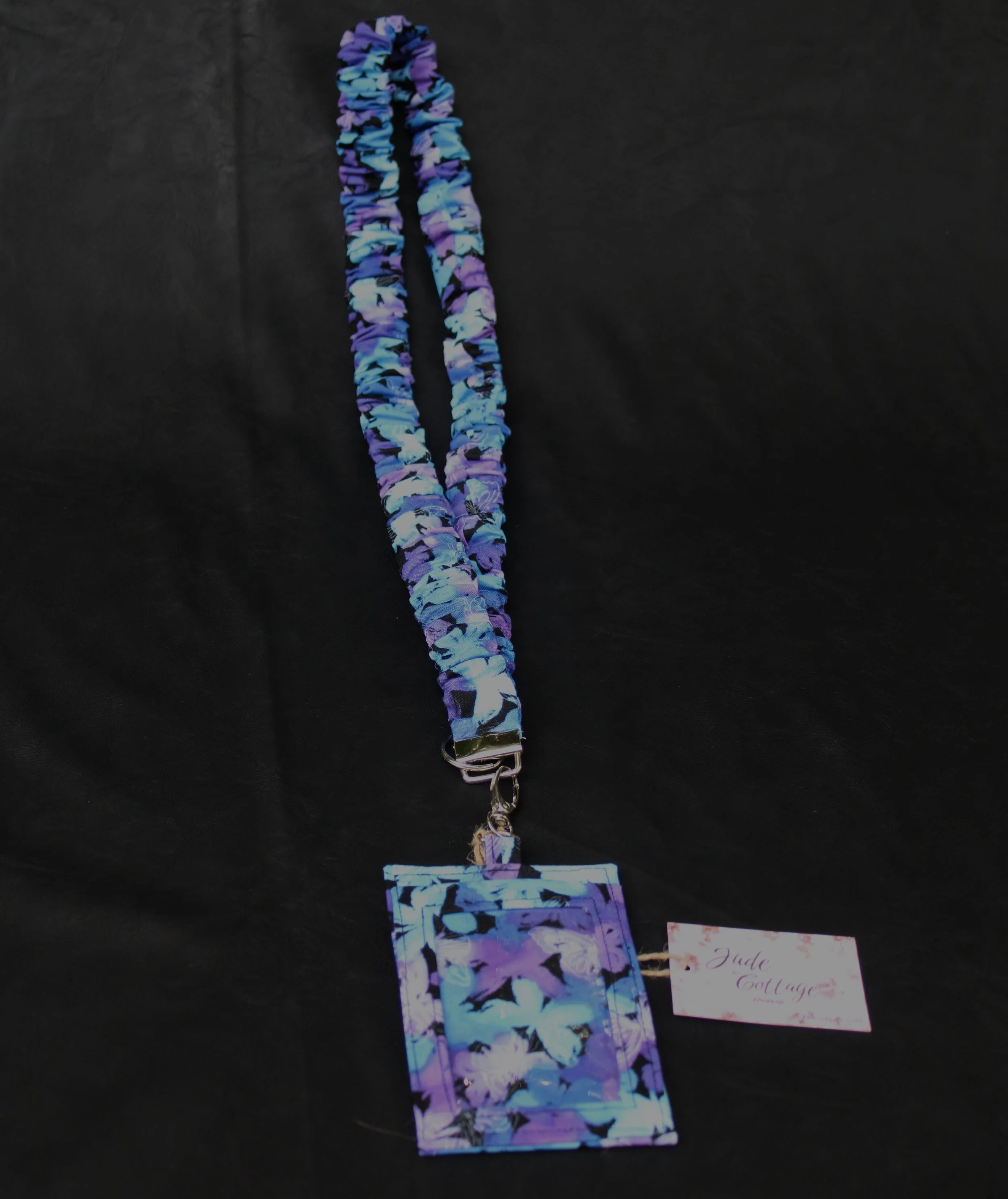 Empty front image of the butterfly mist lanyard and badge holder featuring teal, purple, and white butterfly print.