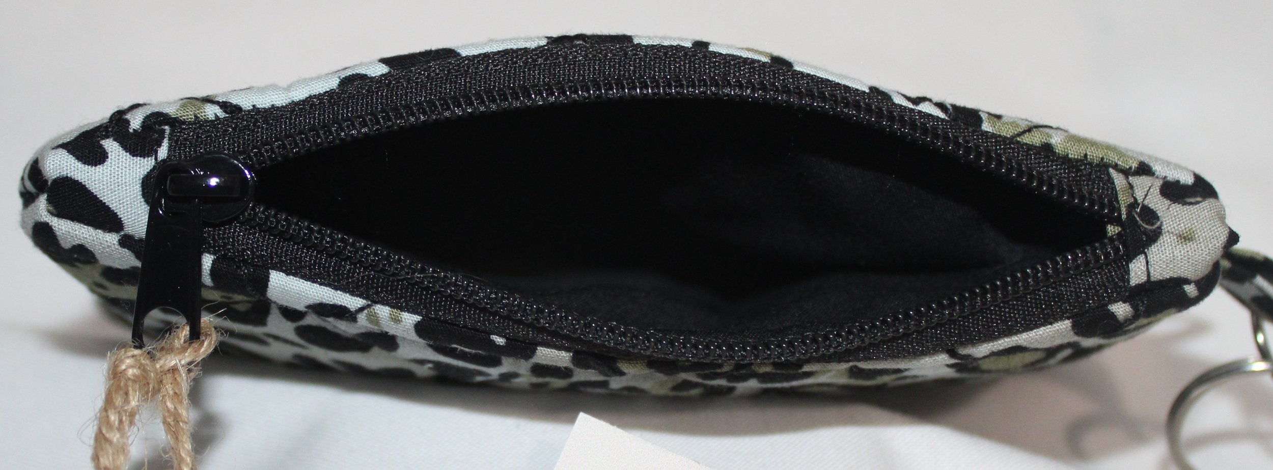 Top view quilted snow leopard wallet with soft animal‑print pattern, zipper closure, and metal key ring.