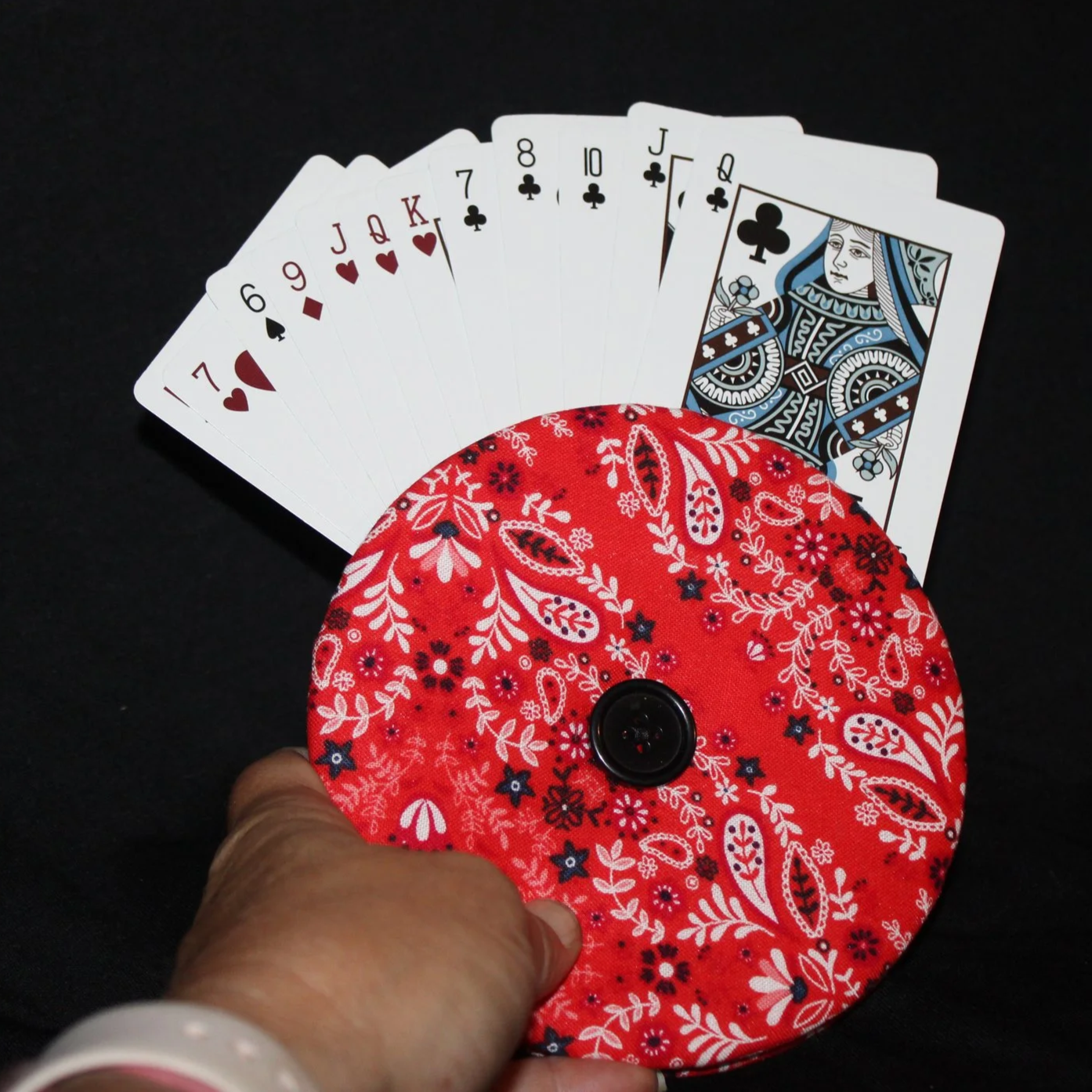 Front view of the Freedom Red Card Holder showing in use with an array of playing cards, featuring red, white, and navy paisley print fabric.
