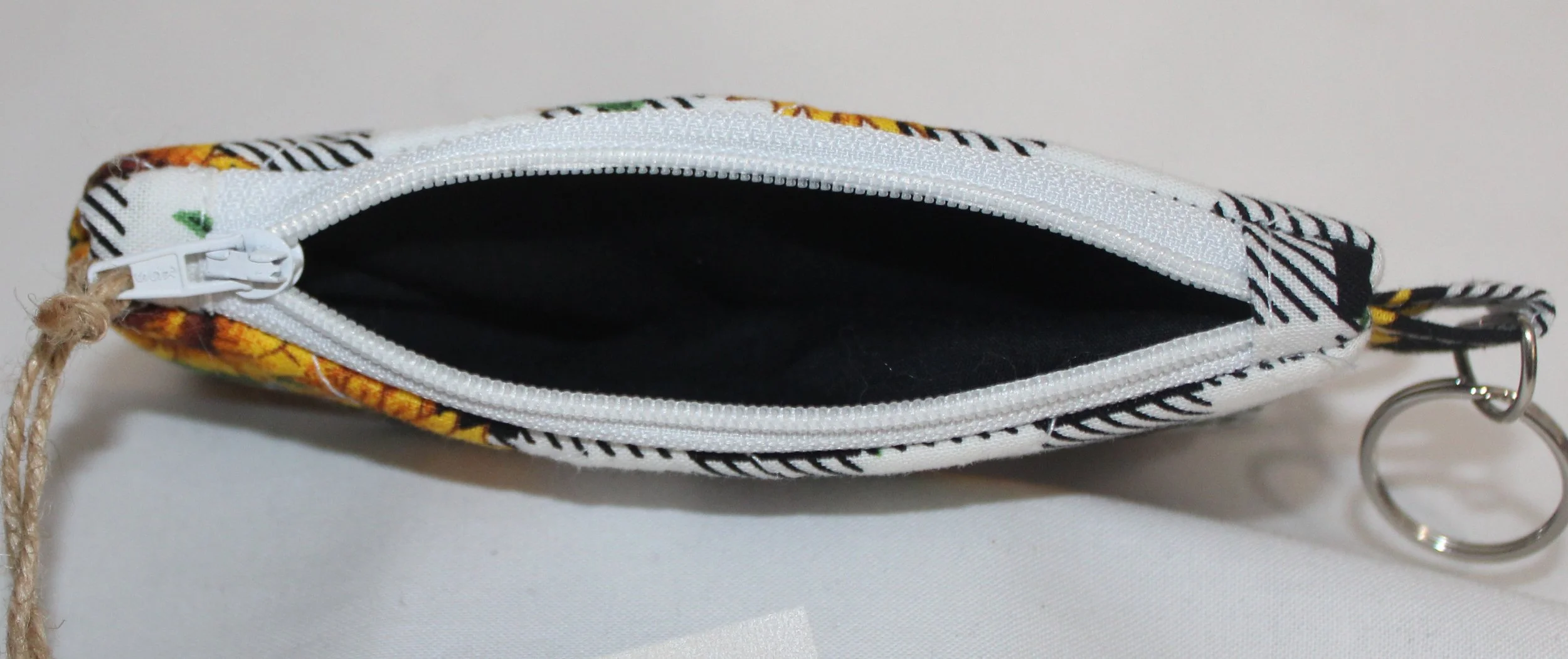 Top view quilted keychain wallet with sunflower and checkered pattern, zipper closure, and metal key ring.