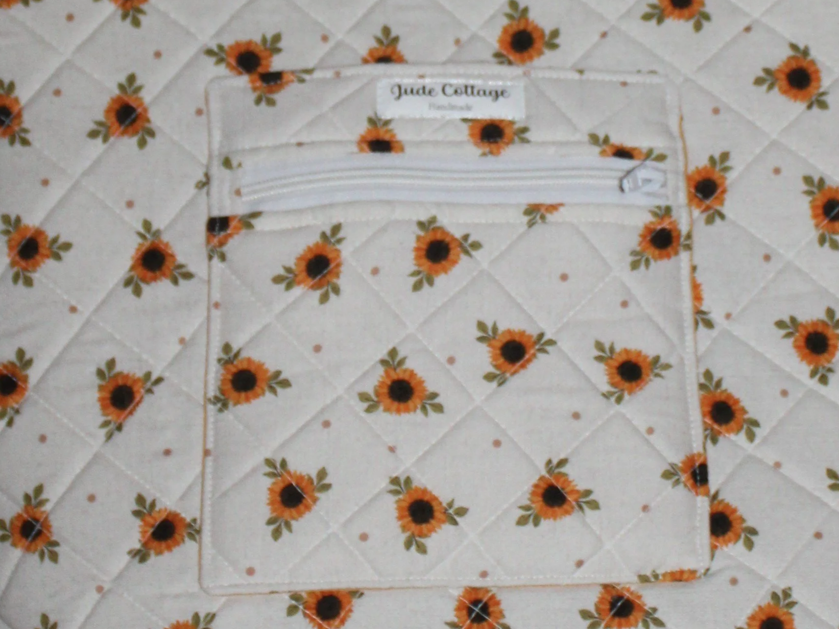 Up-close front view of the Sunflower Medley quilted tote, showing the exterior slip pocket and exterior zip pocket along with the quilted pattern.