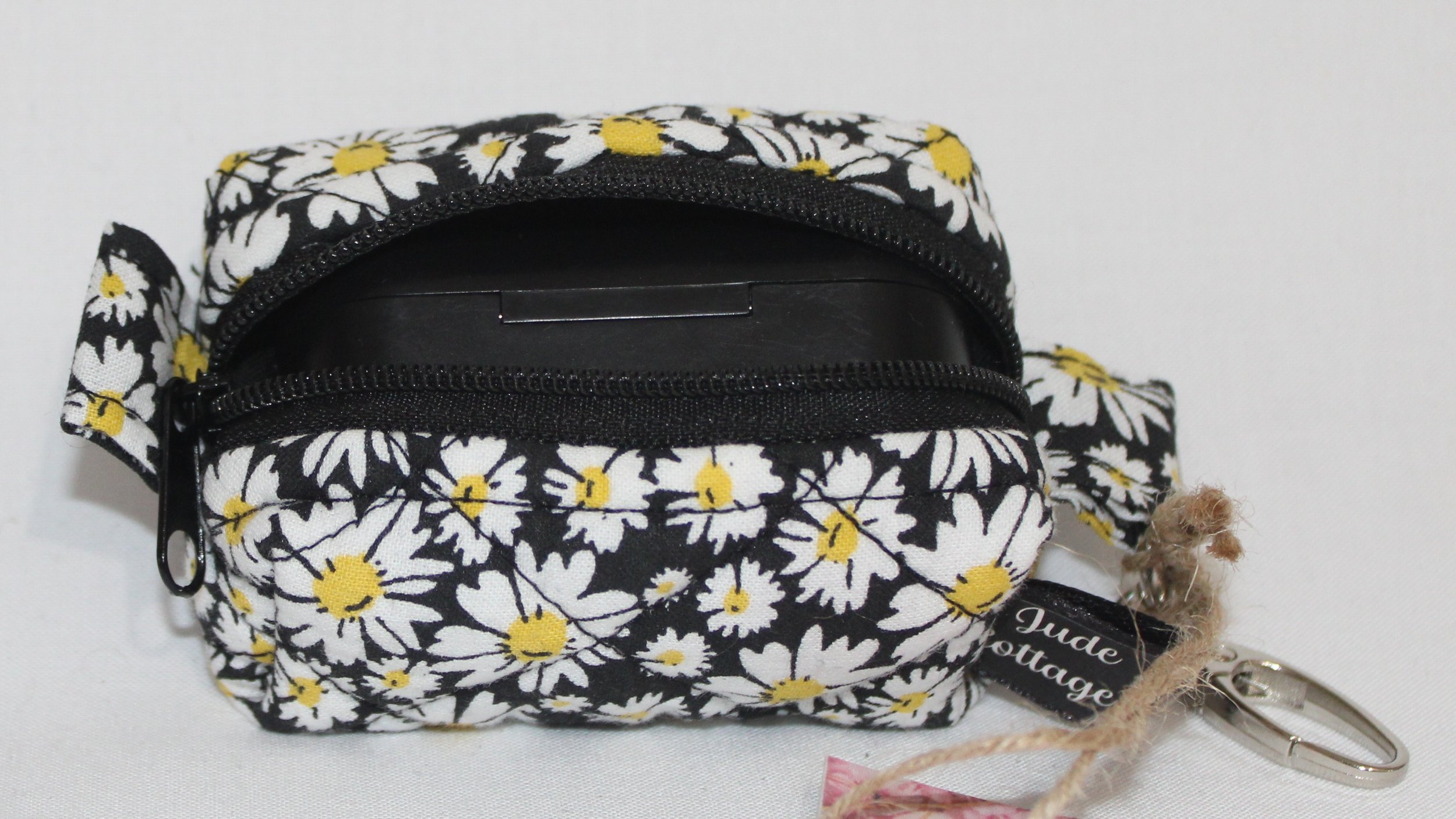 Top open view of the Ditzy Daisy Bag Charm showing zip enclosure and a J Lab case inserted for size reference.