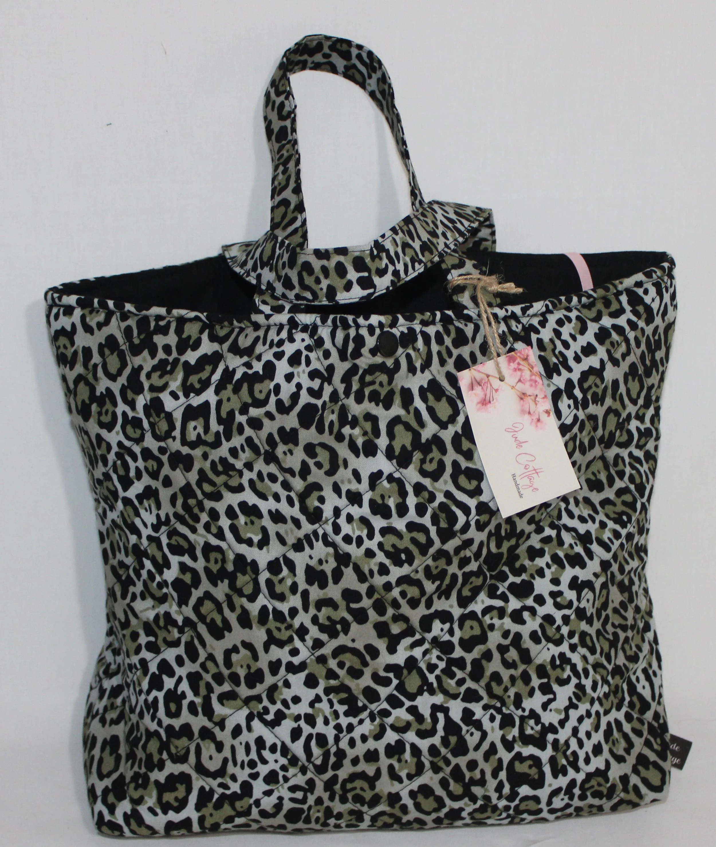 Front view of the Diana quilted Bible sleeve with snow leopard print fabric and two carry handles.