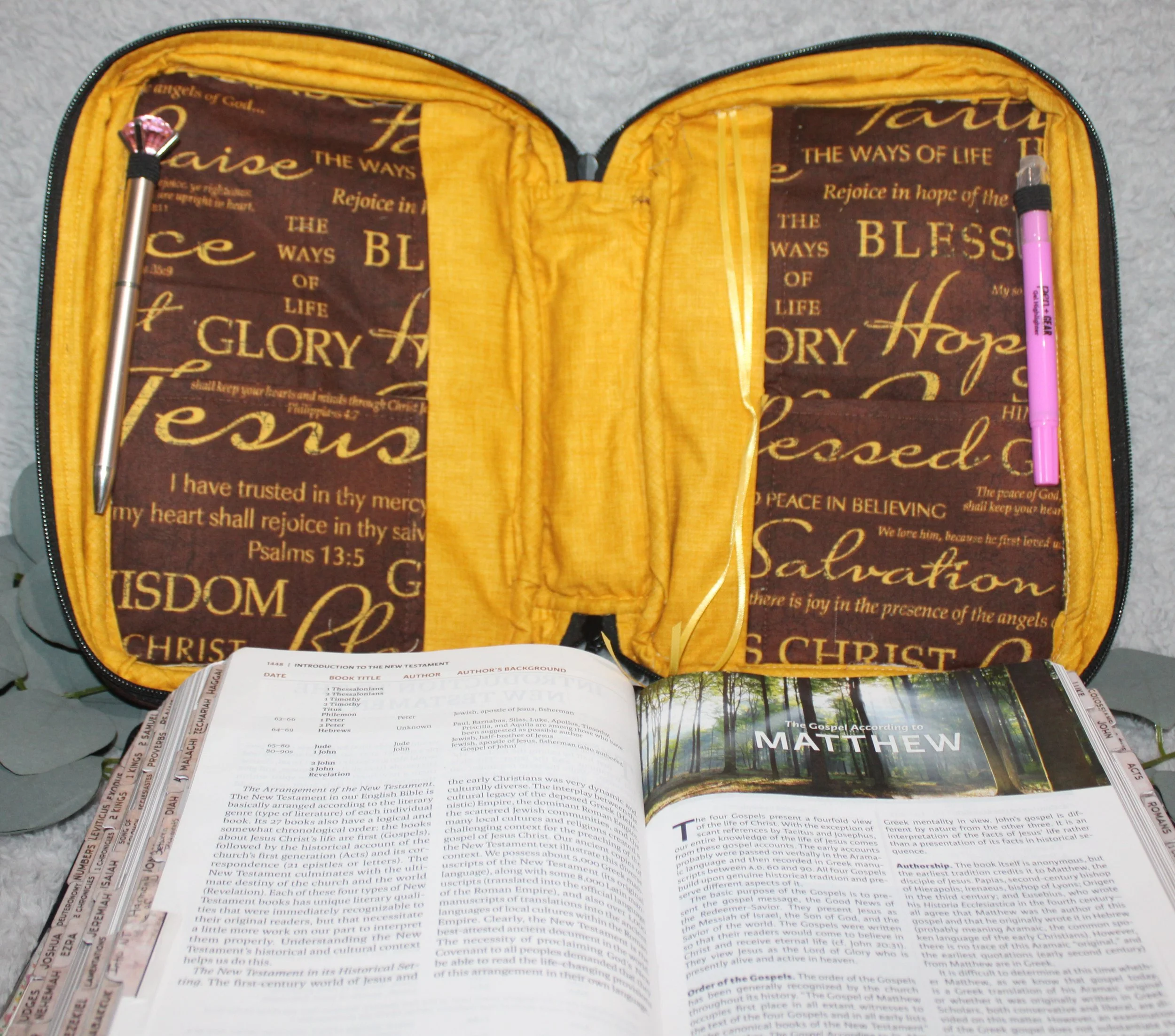 Empty interior view of the Rejoice Study Bible Case showing the brown main fabric and gold interior lining, slip pockets, and pen holders.