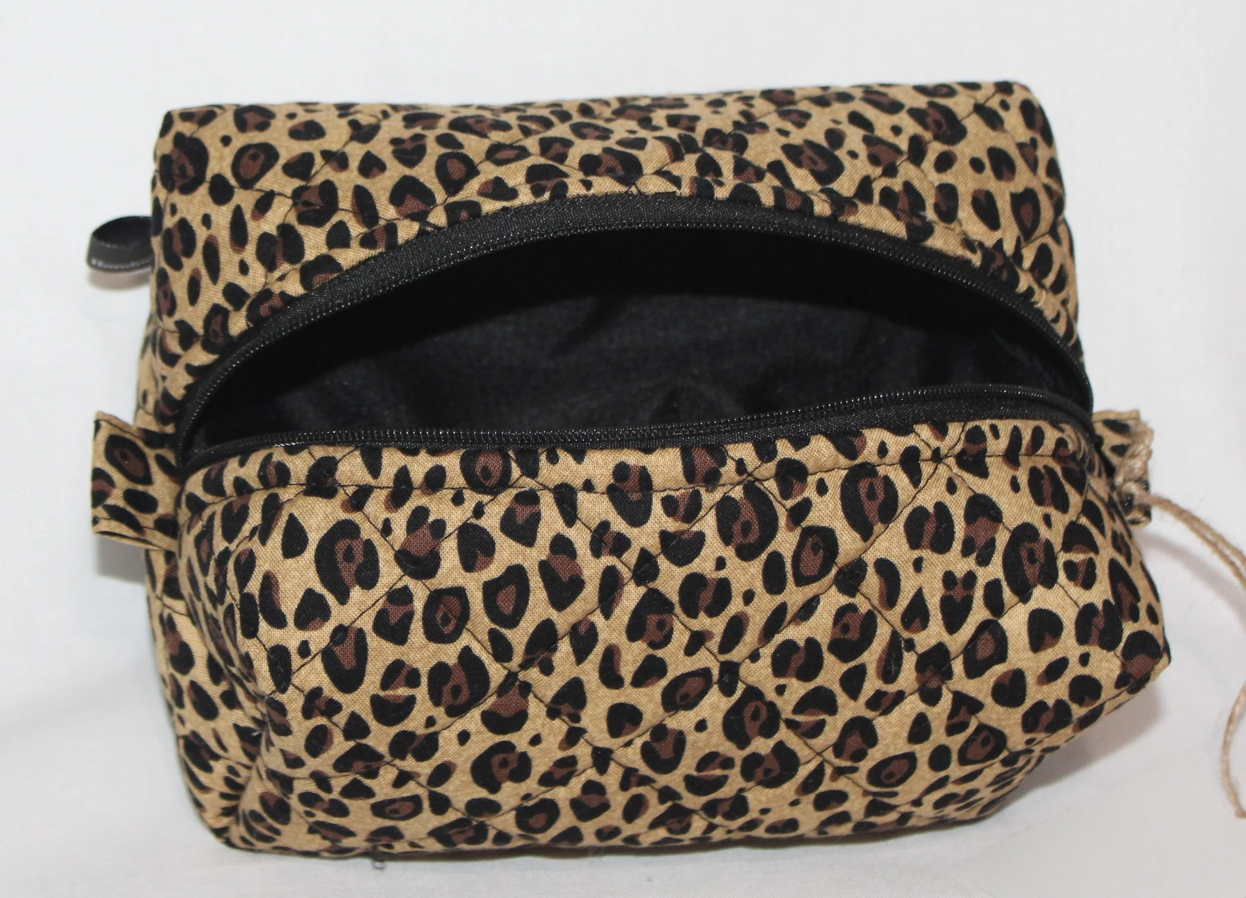 Top view of the Sahara cheetah‑print travel pouch with the zipper fully open, revealing the empty lined interior.