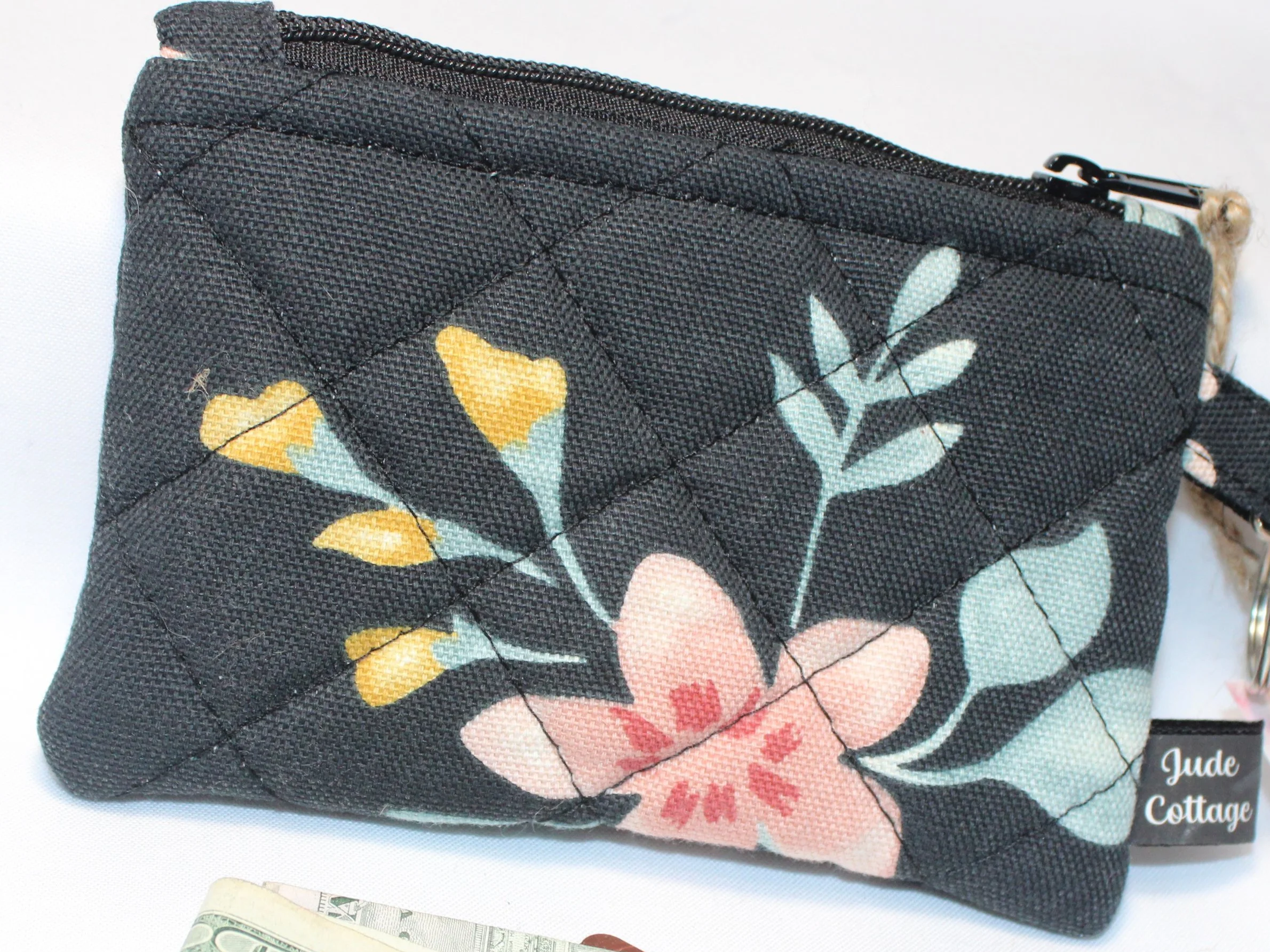 Close-up view of the Twyla quilted keychain wallet with bold artistic pattern, zipper closure, and metal key ring.