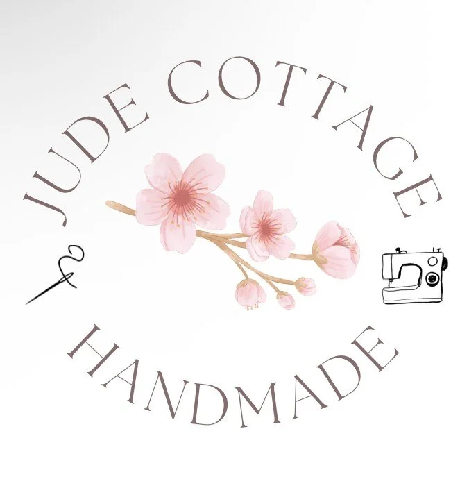 Logo with pink cherry blossoms, circular text saying 'Jude Cotte & Handmade,' and a small sewing machine icon.