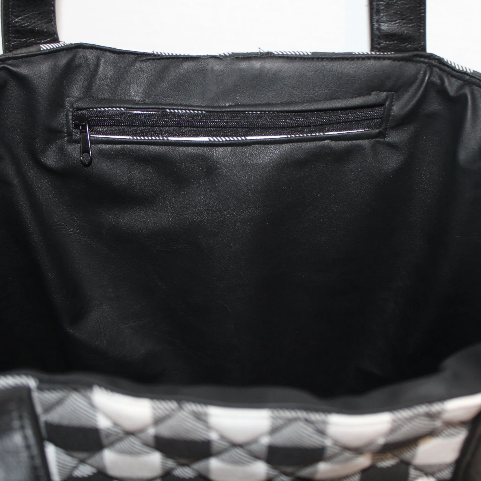 Up close view of the interior zip pocket and faux leather lining.