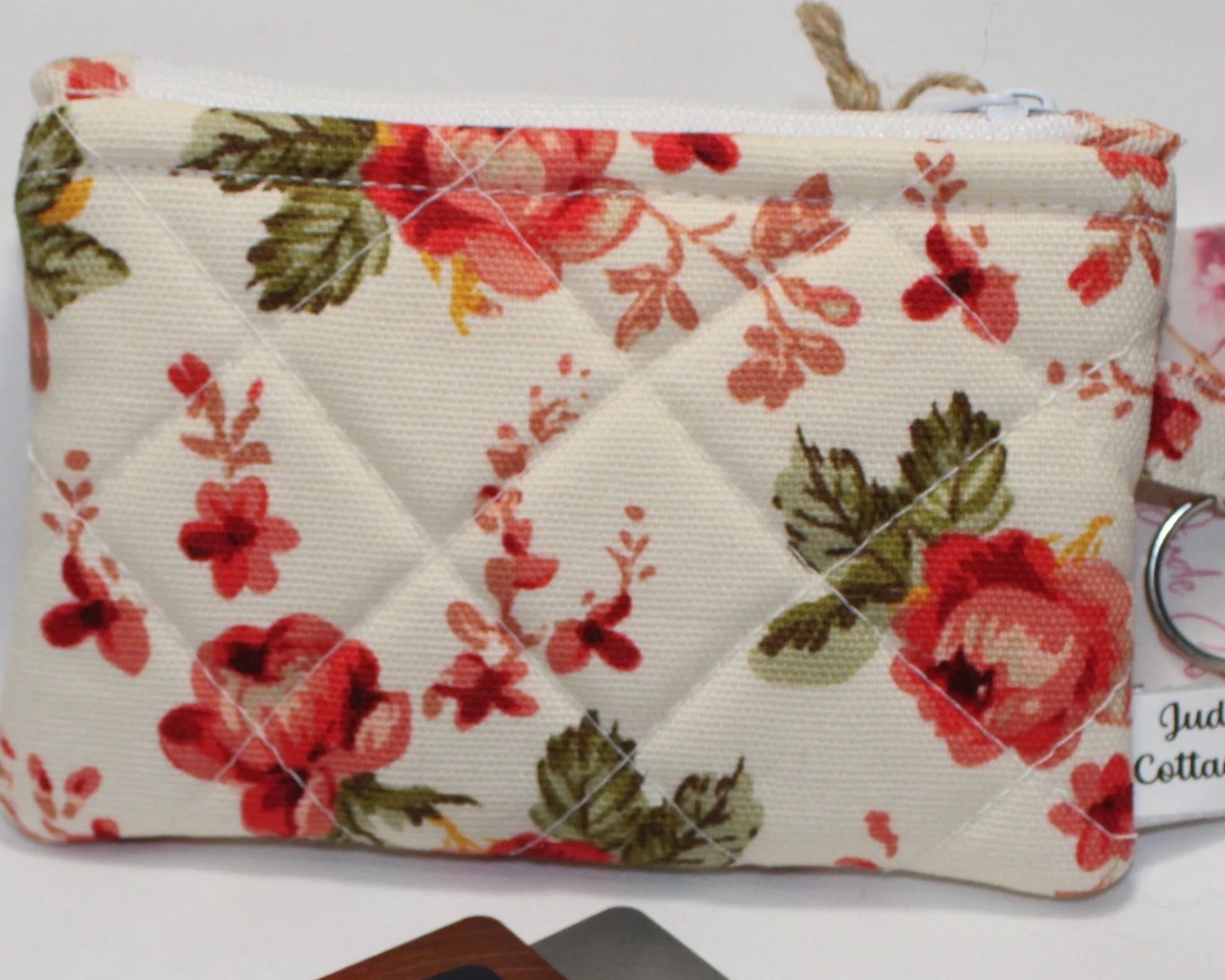 Quilted keychain wallet with English rose floral pattern, zipper closure, and metal key ring.