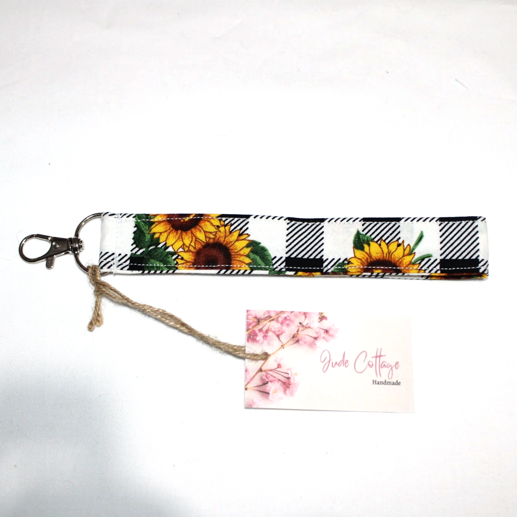 Closeup of the Sunflower Check Wristlet, with black and white plaid background with vibrant sunflower pattern.