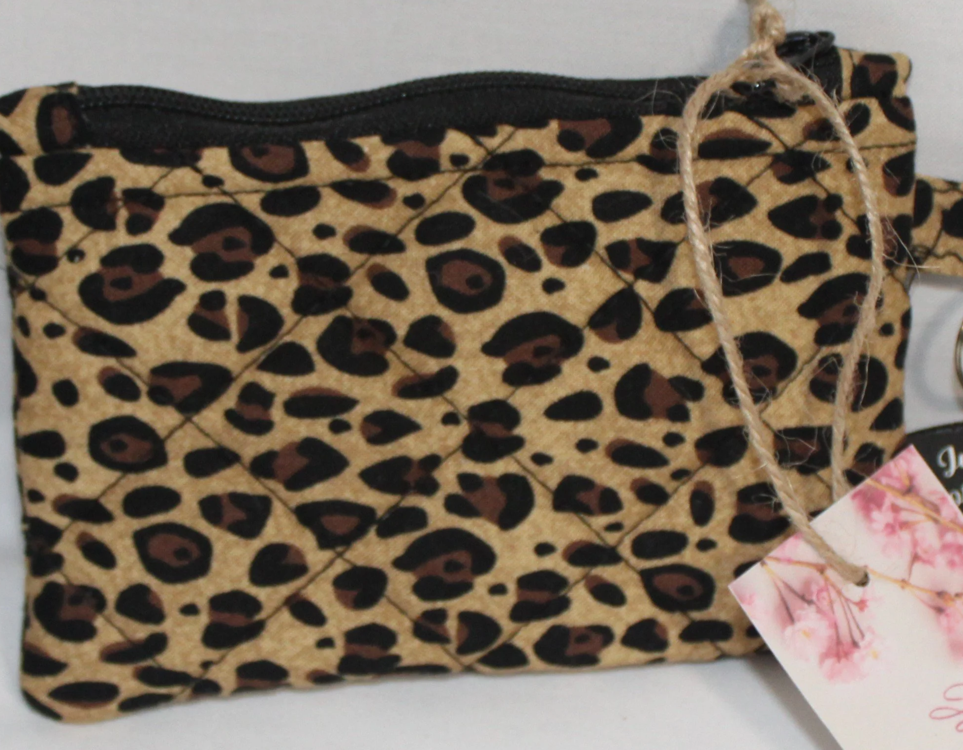 Up-close view of the Sahara, cheetah print keychain wallet with zipper closure and metal keyring.