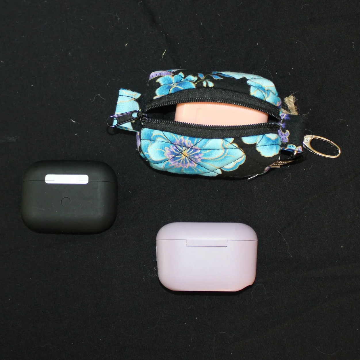 Top view of open zippered Twilight Paisley Bag Charm shown with an airpod earbud case inserted for sizing reference.