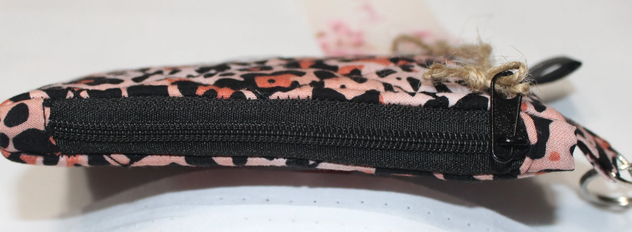 Top closed view of the Mia quilted keychain wallet showing the black zip top.