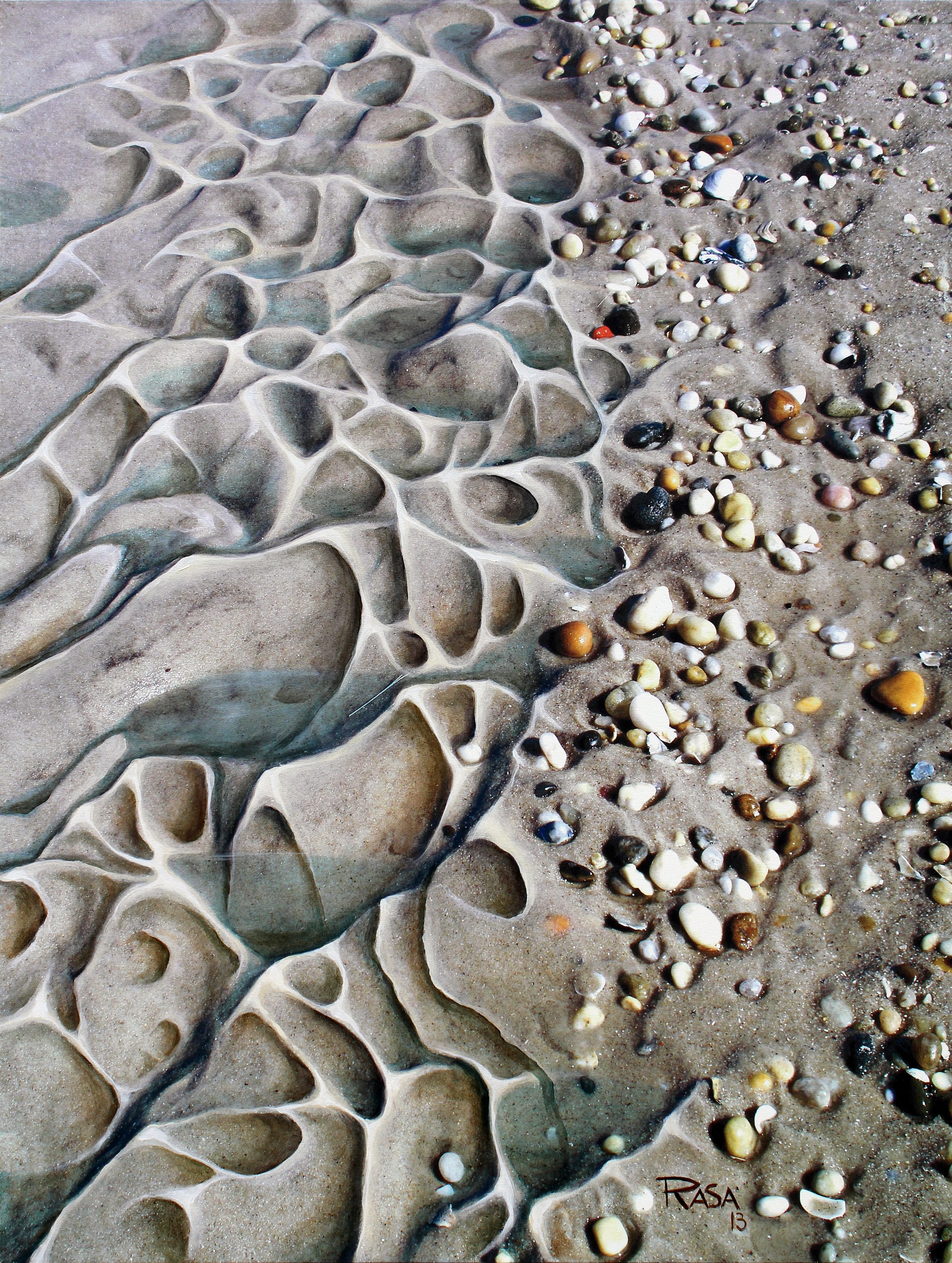 A close-up of a sandy beach with intricate, naturally-formed patterns carved into the sand, accompanied by scattered small, smooth pebbles of various colors and sizes.