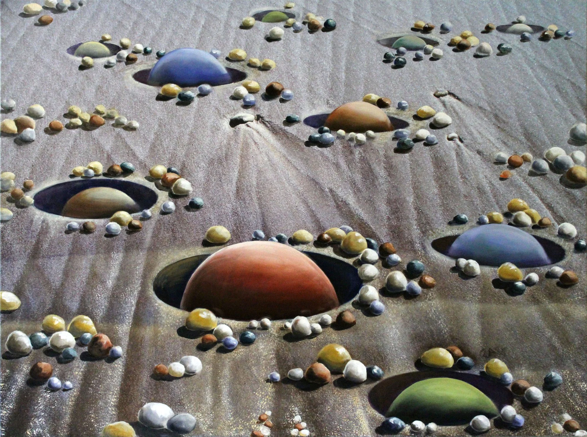 Colorful pebbles and stones arranged on a sandy surface with small holes or depressions, creating an abstract pattern.