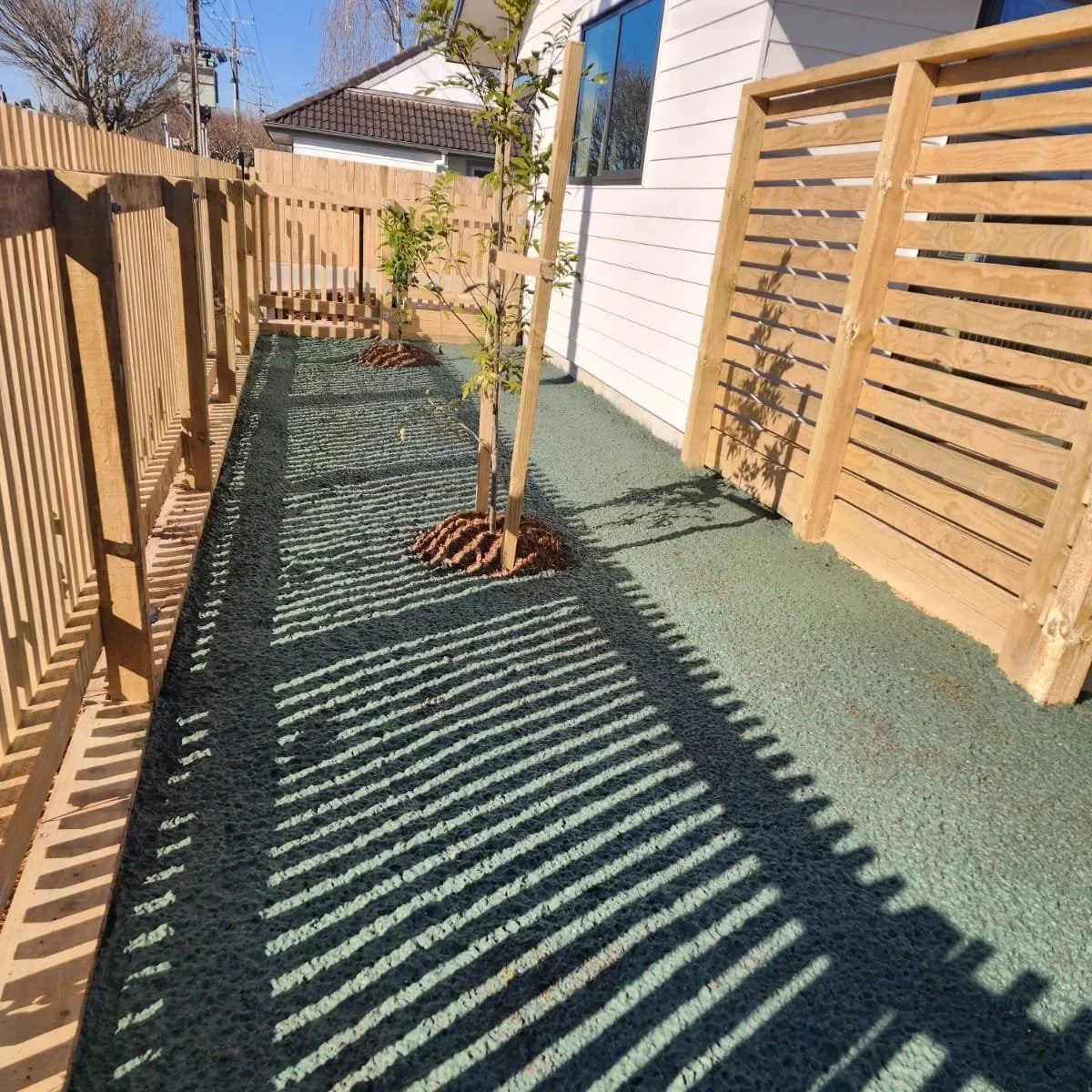 Hydroseeding in a residential property, surrounding new planting.