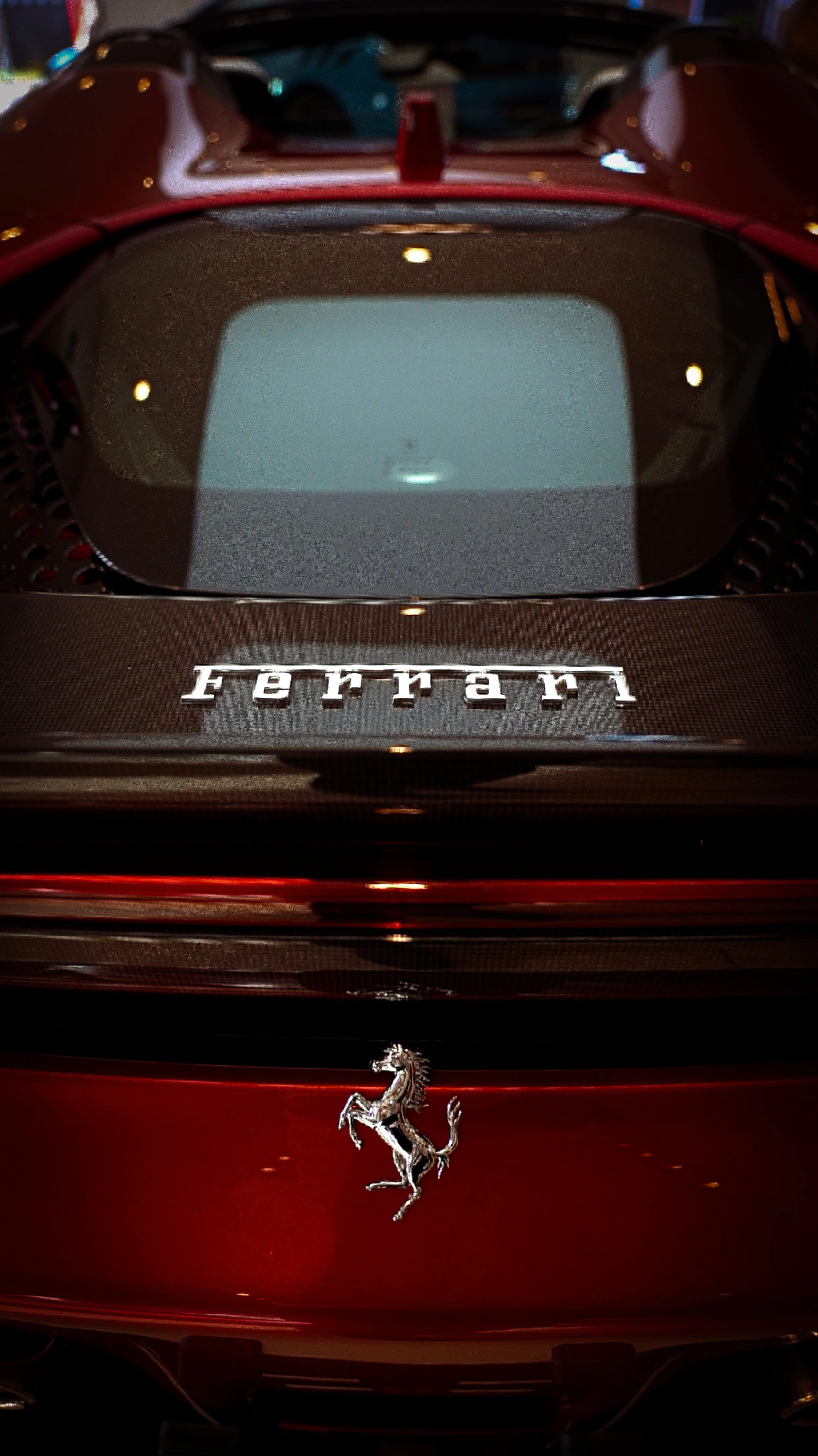 Close-up of the rear of a red Ferrari sports car, displaying the Ferrari logo and emblem.