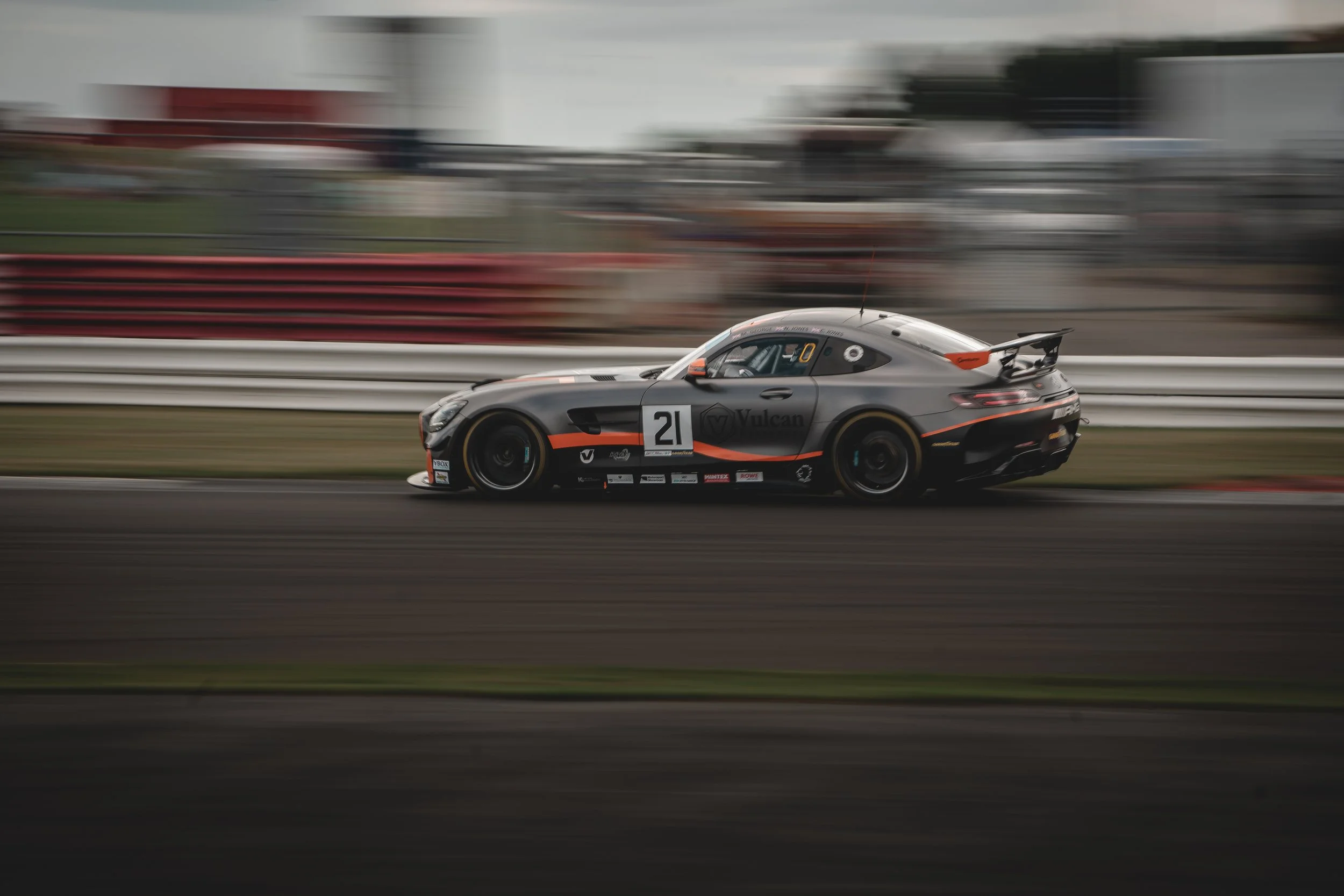 A race car speeding on a track with motion blur background.