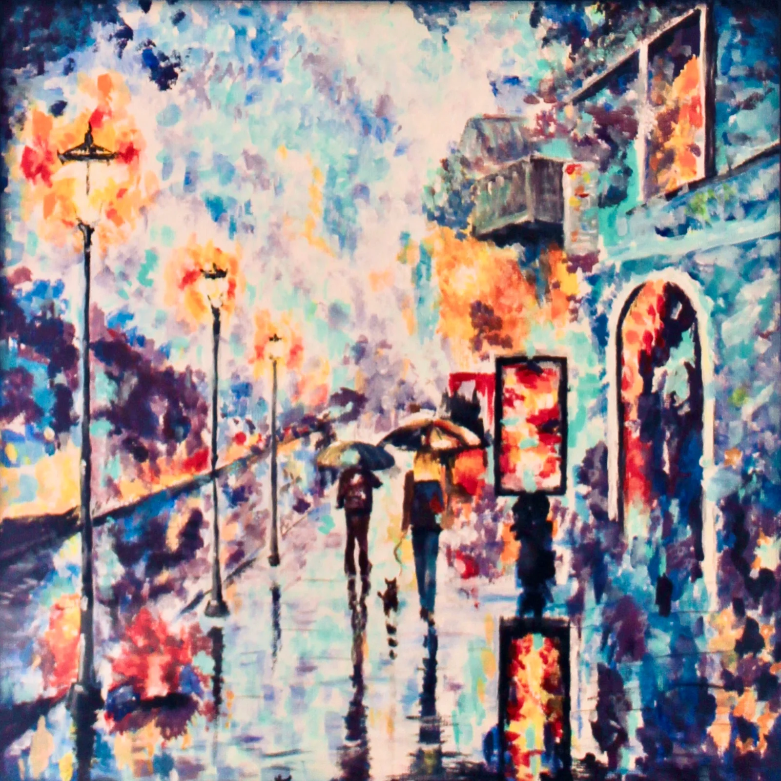 A colorful impressionist painting of a rainy city street. The scene includes pedestrians with umbrellas, lampposts, and reflections on wet pavement, with trees and buildings in the background.