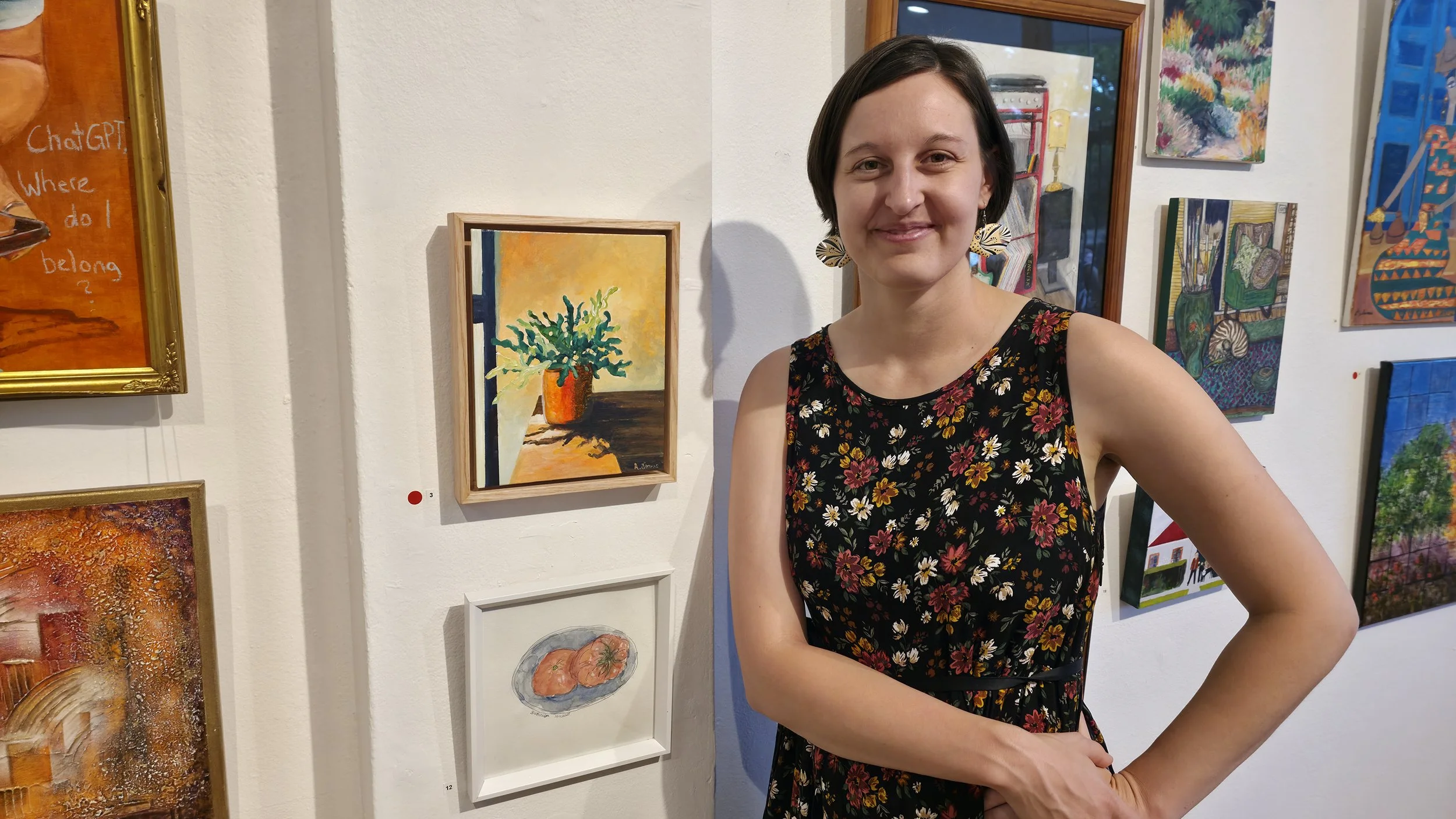 Artist stands in front of sold painting