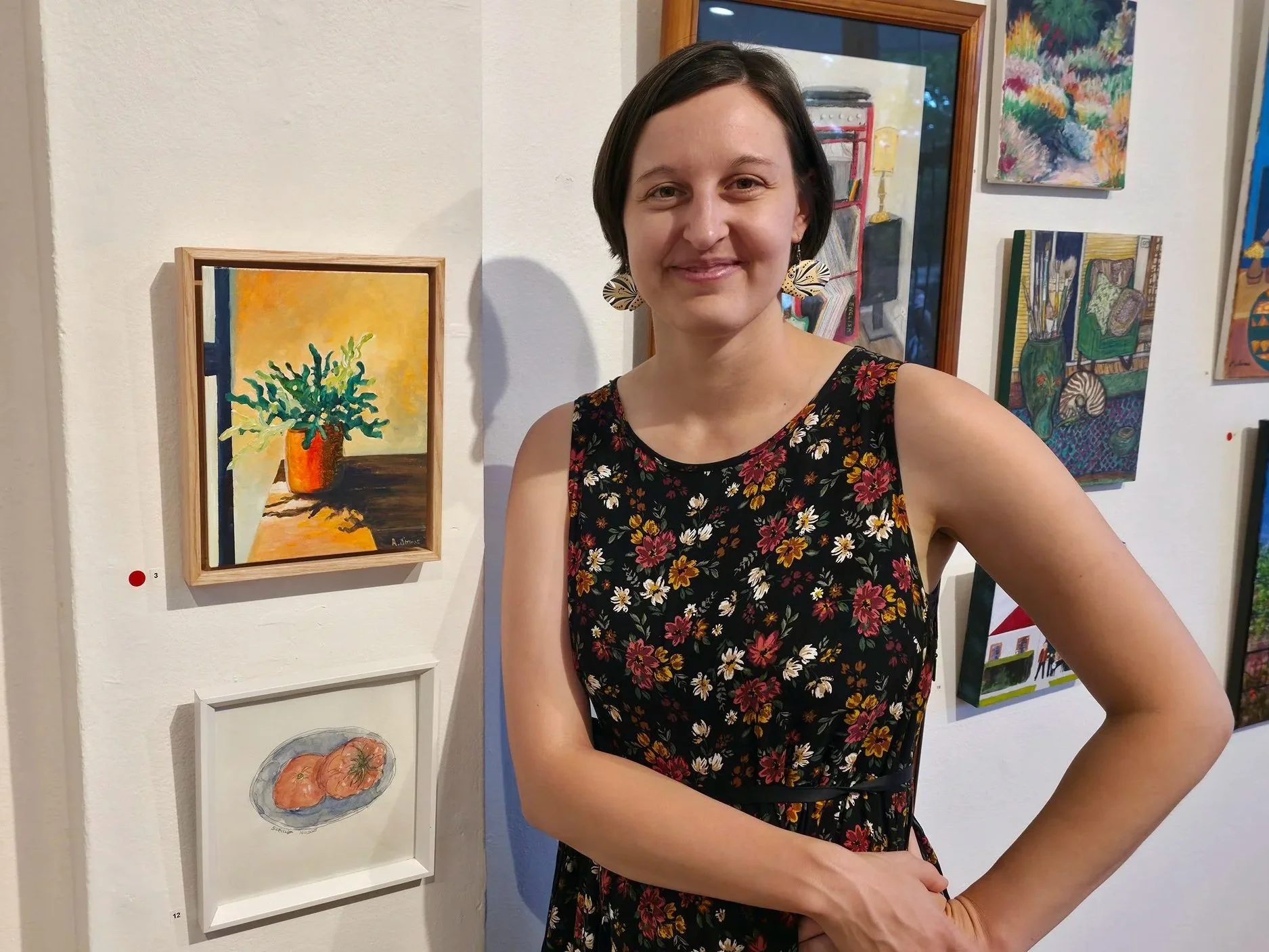 Artist stands next to a sold painting