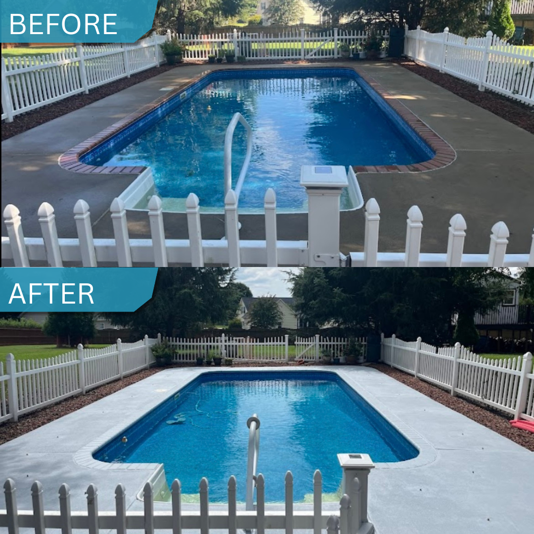 A backyard swimming pool surrounded by a white picket fence, with tall trees and suburban houses in the background, under a partly cloudy sky.