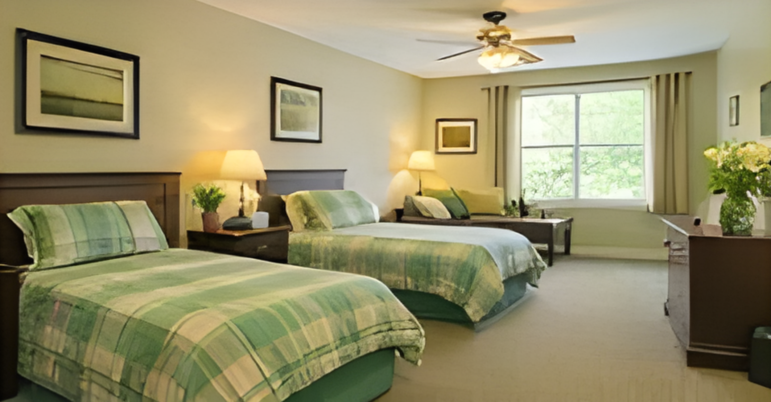 A hotel room with three single beds, each with green plaid bedding, bedside tables with lamps, a window with beige curtains, and a dresser with a vase of flowers.