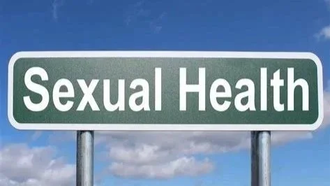 Road sign reading 'Sexual Health' against blue sky and clouds.
