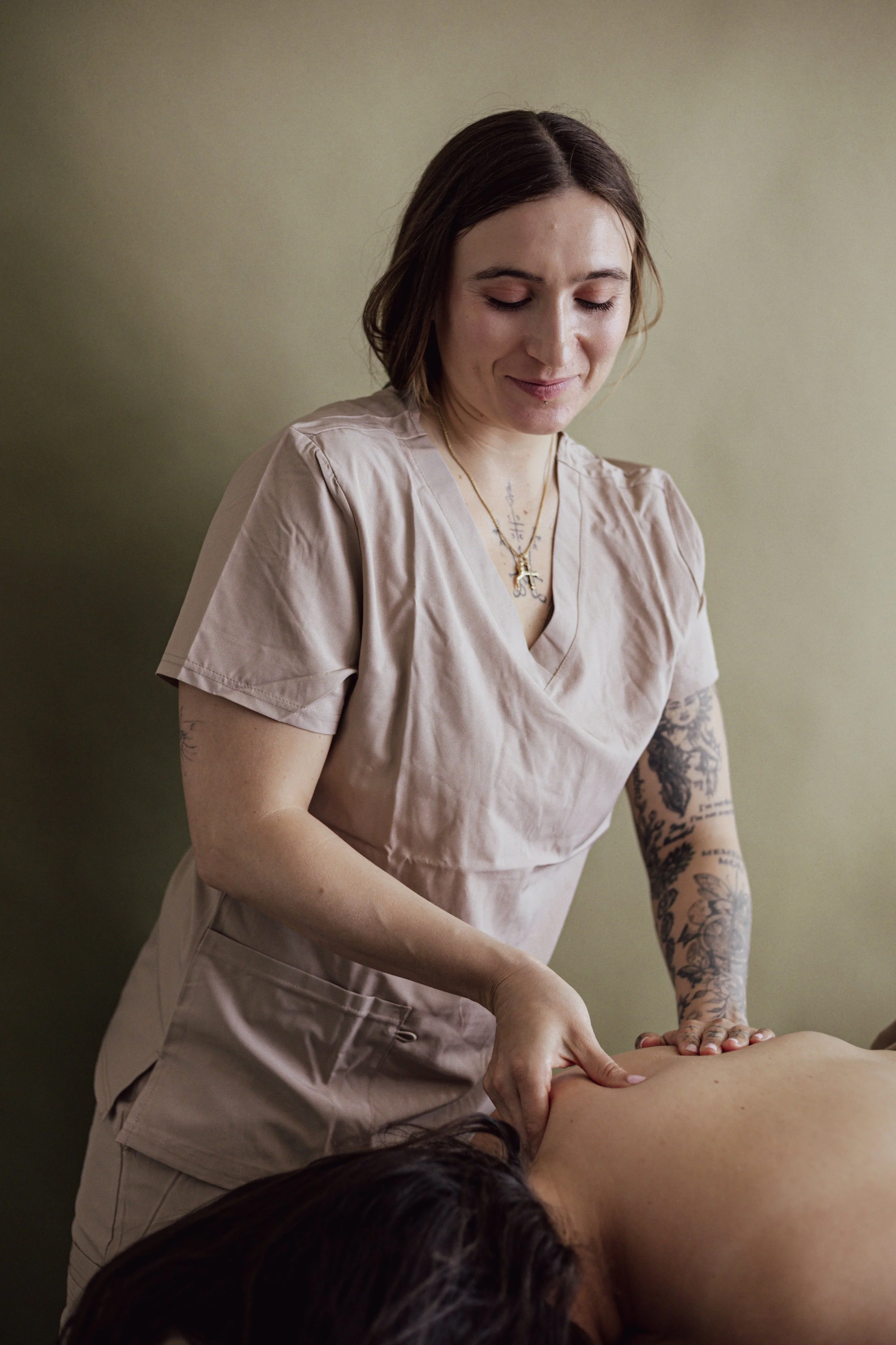A woman receiving a massage from a massage therapist in a spa or wellness center.
