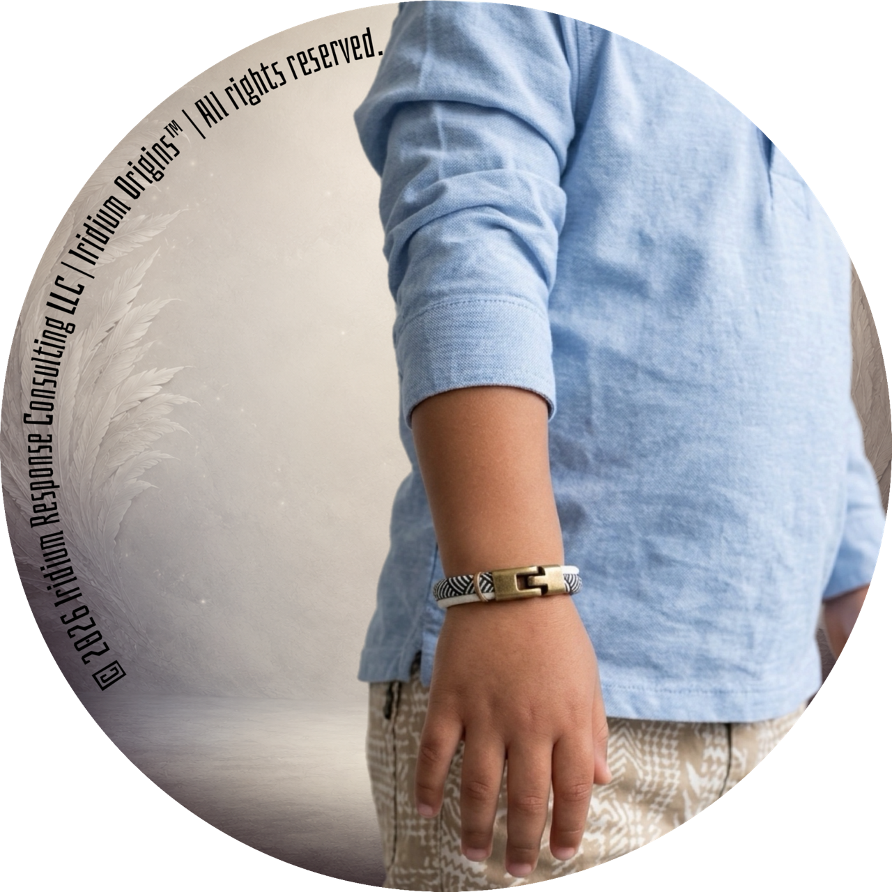 Close-up of a wrist wearing a striped bracelet with a light blue sleeve and patterned pants.