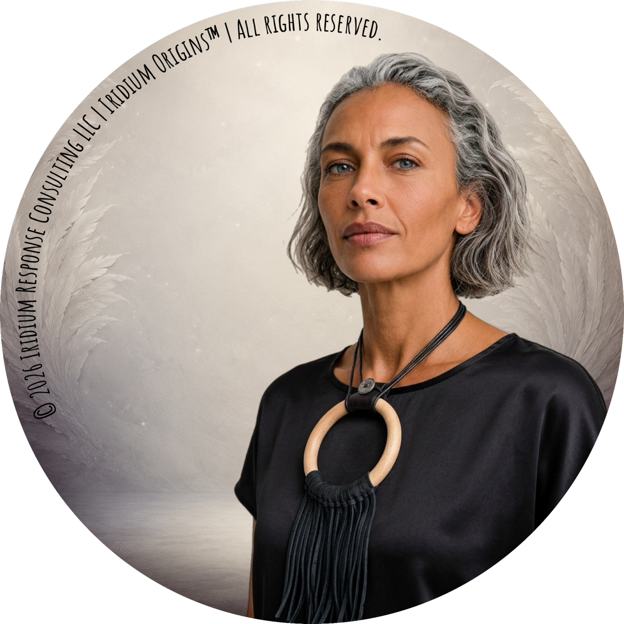 Woman wearing a black top and a bold black-and-beige necklace against a feathered Iridium background.