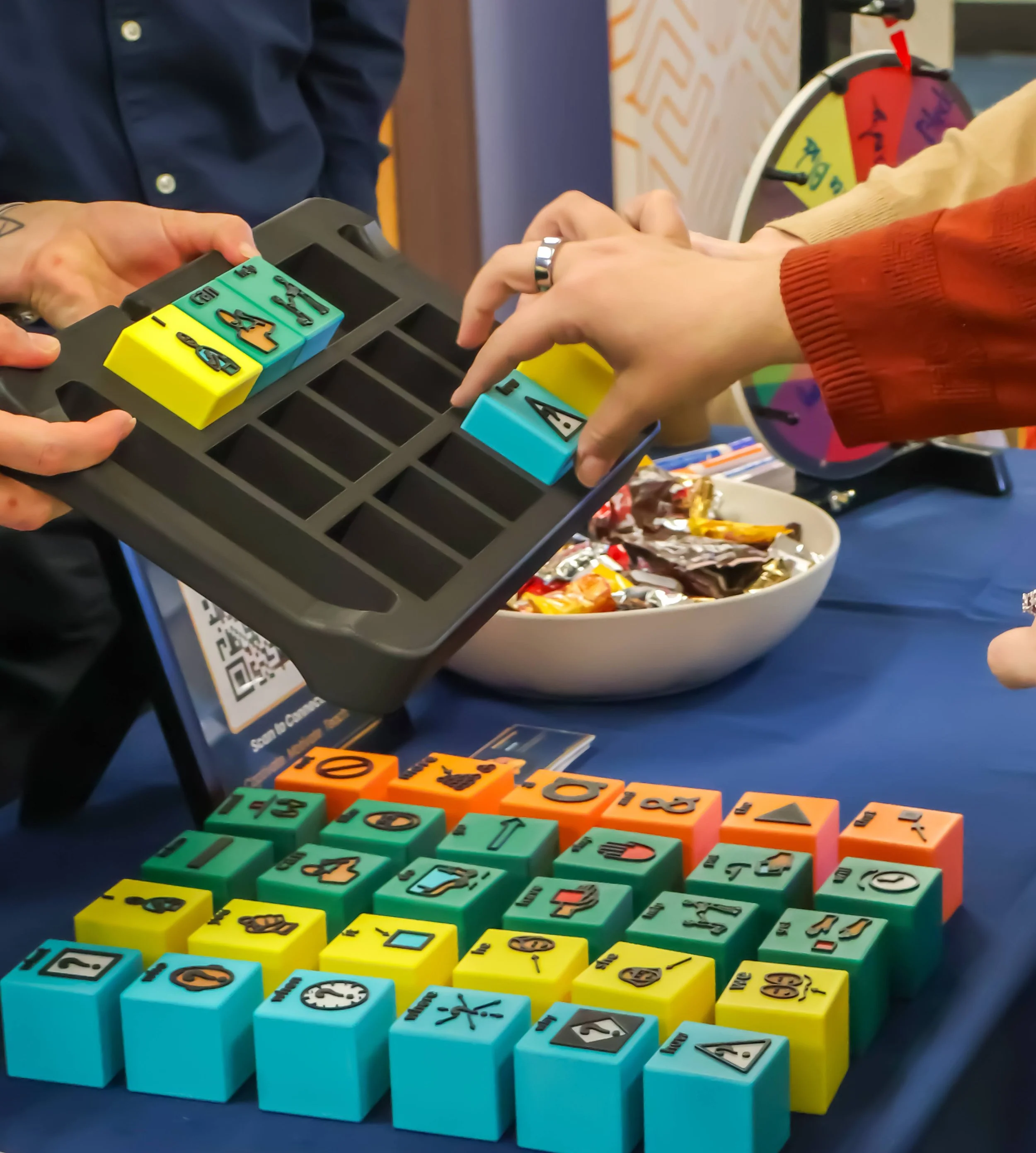 Hand placing a tactile AAC block on the table during a Tactile Voices demo at CSHA 2026