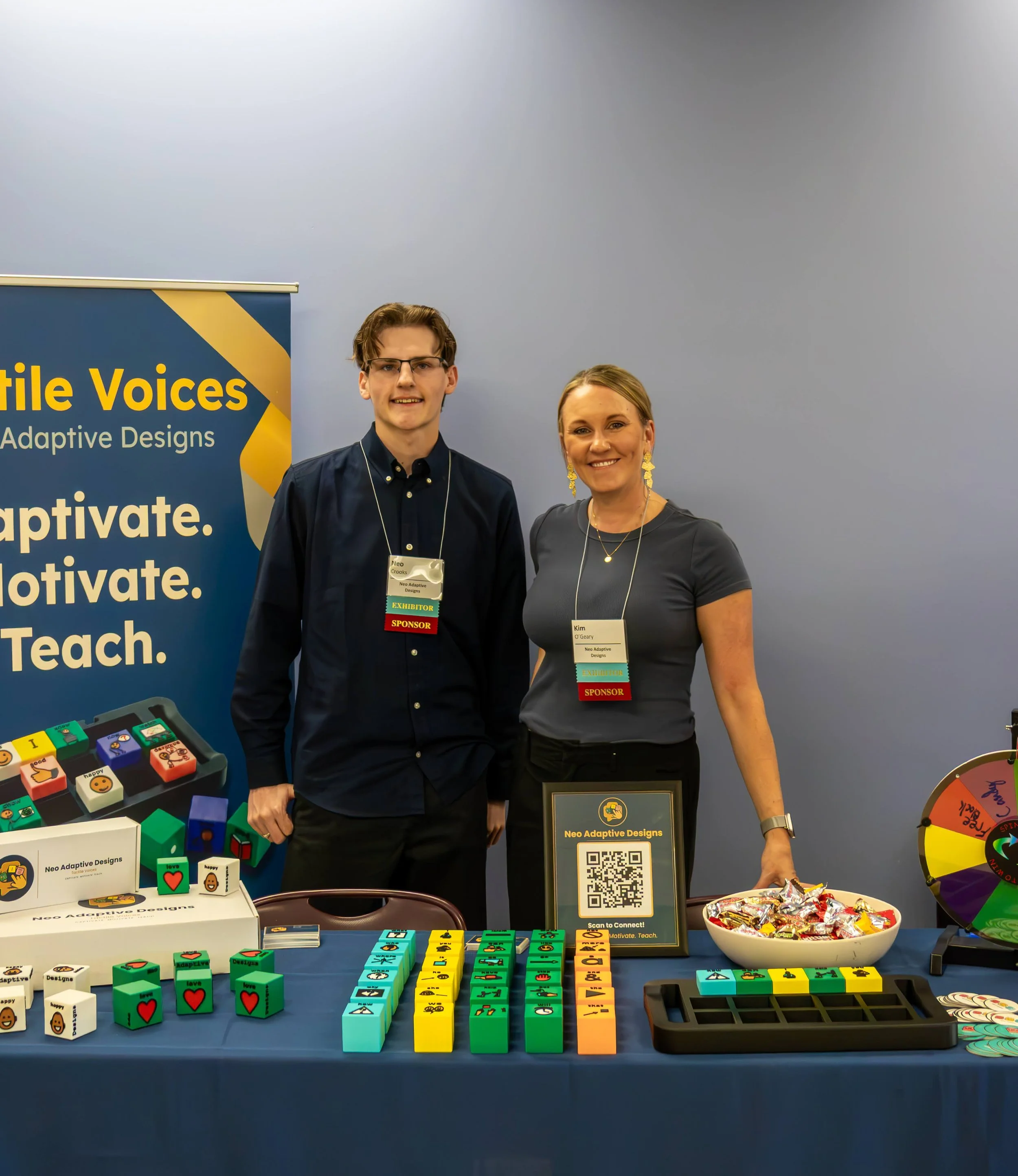Neo-Adaptive Designs team at the Tactile Voices booth at CSHA 2026, with tactile AAC block displays on the table