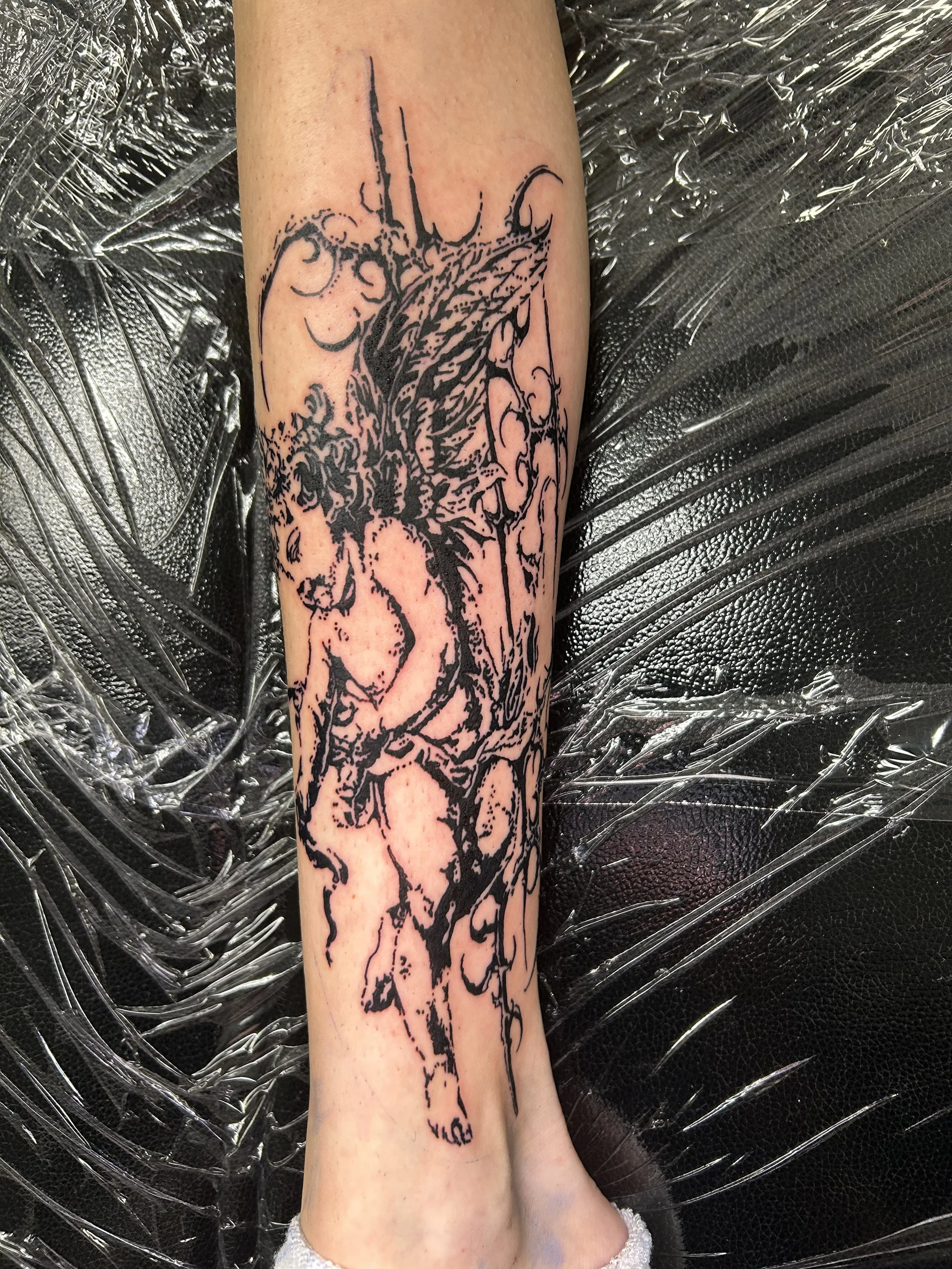 Tattoo of a mythical dragon creature on a person's forearm, with detailed black ink linework.