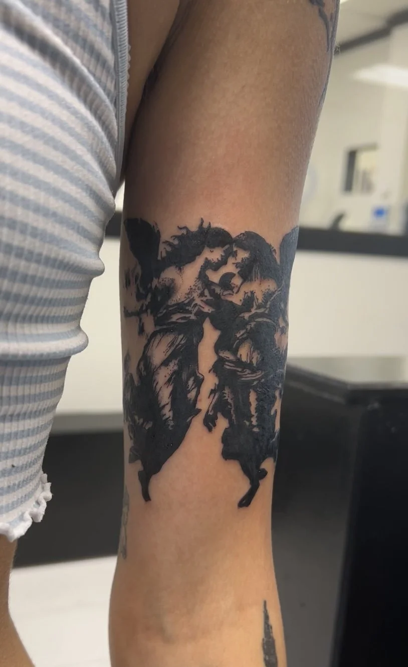 Black tattoo of Lady Gaga on person's upper arm