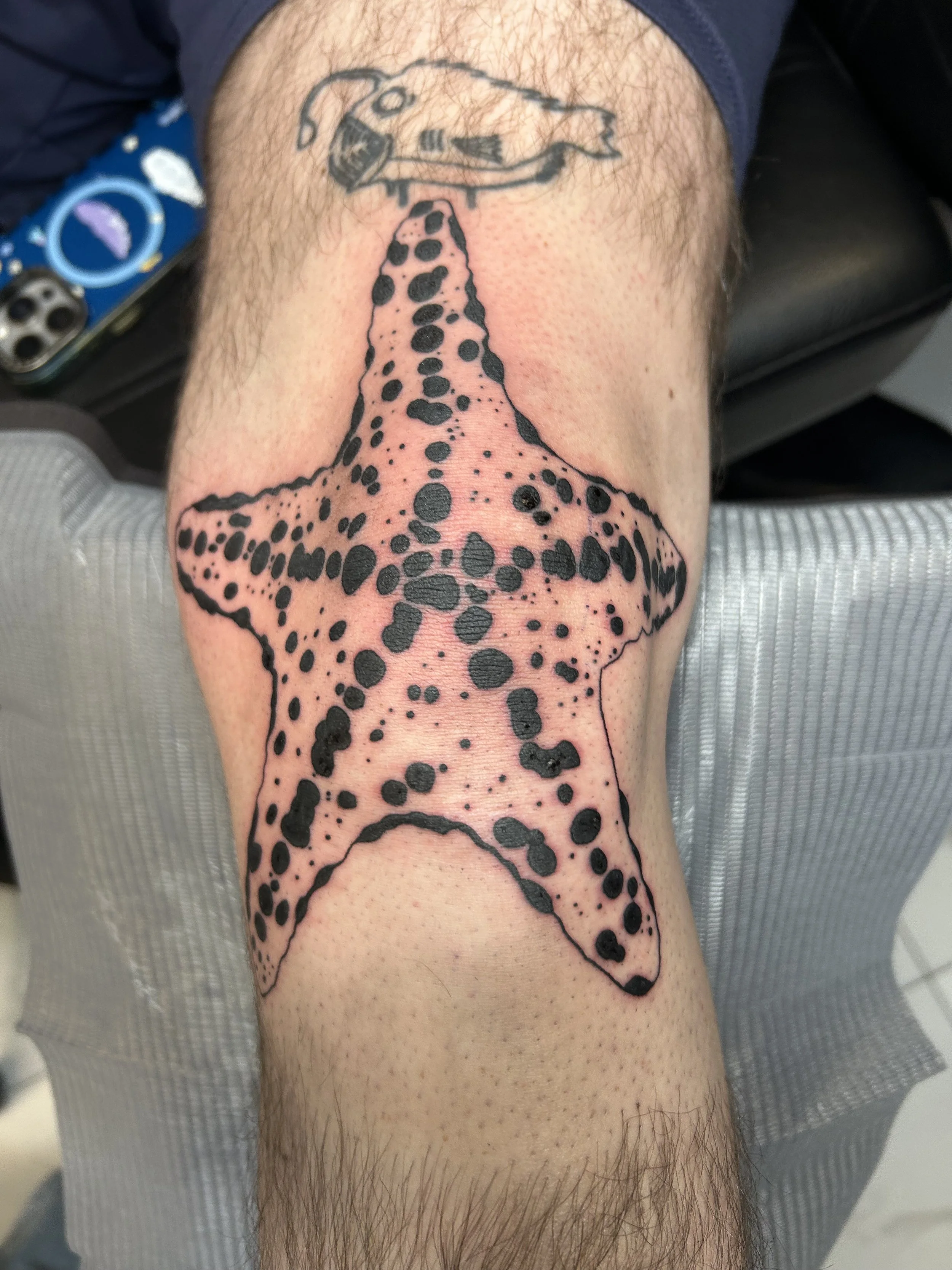 Tattoo of a giraffe with a helicopter on its head on a person's leg.