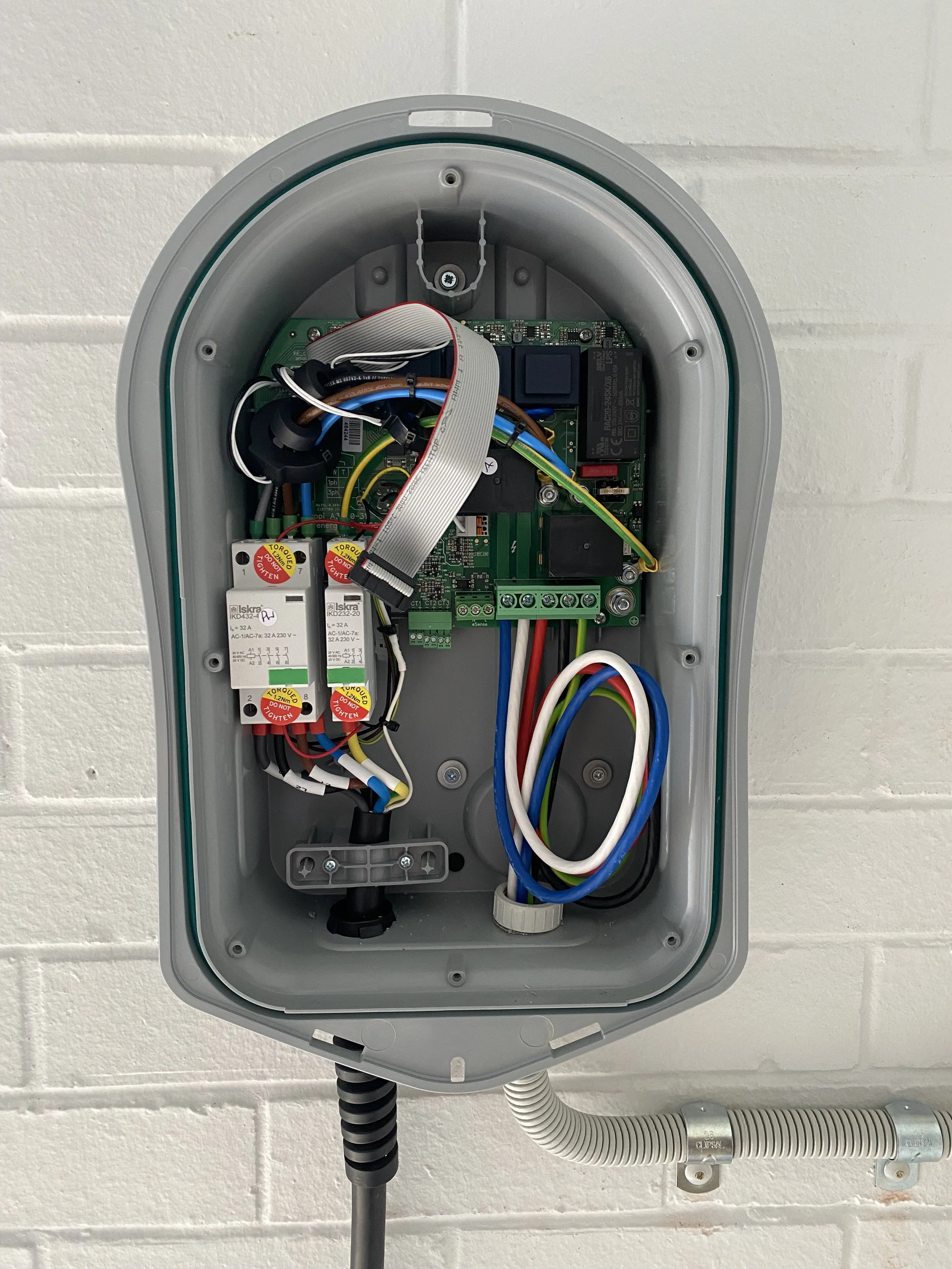 Open electrical control box showing circuit boards, wires, and relays mounted inside.