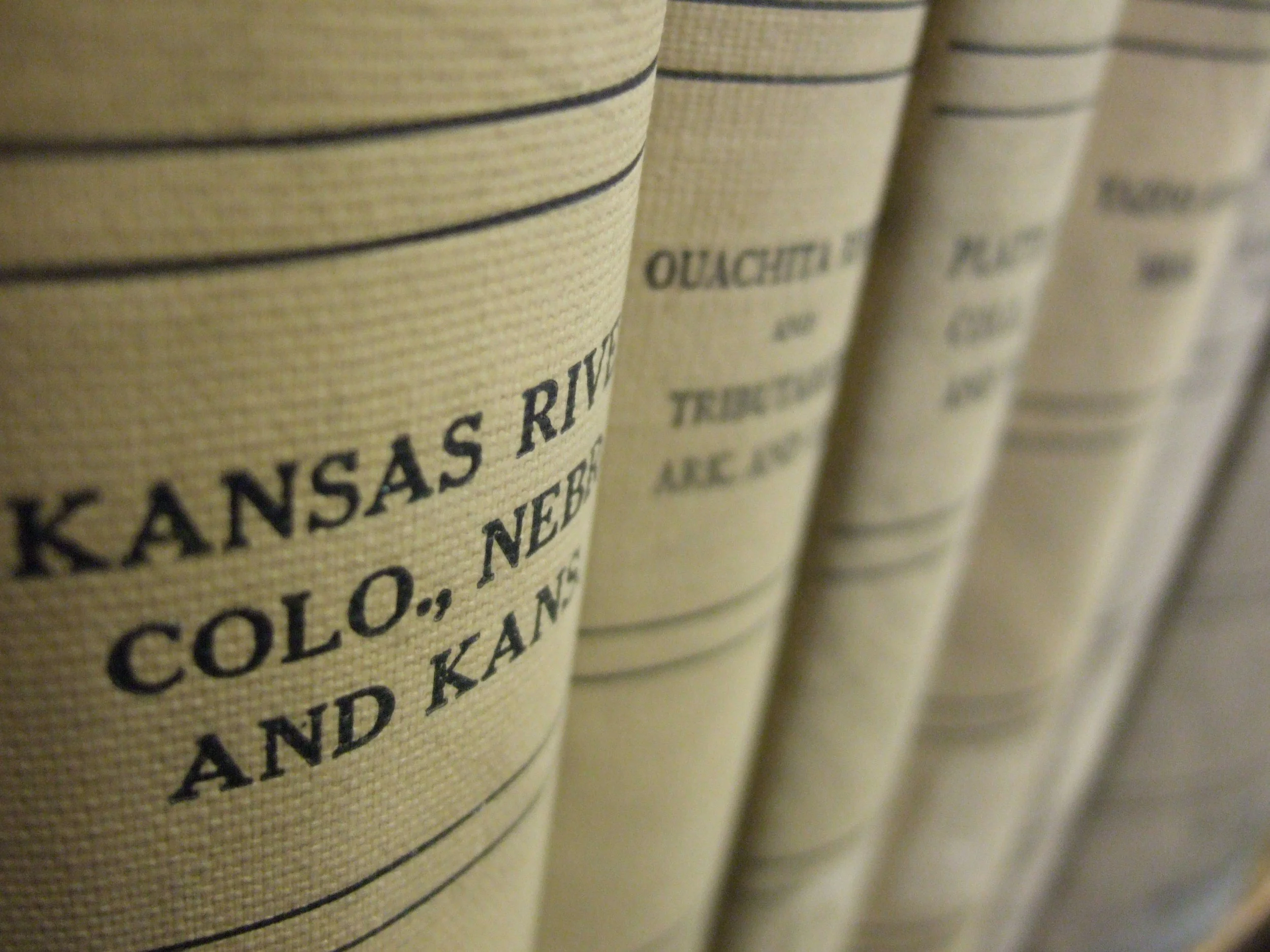 Close-up of vintage canned food labels on stacked cans, displaying text such as 'Kansas River' and 'Ought'.}