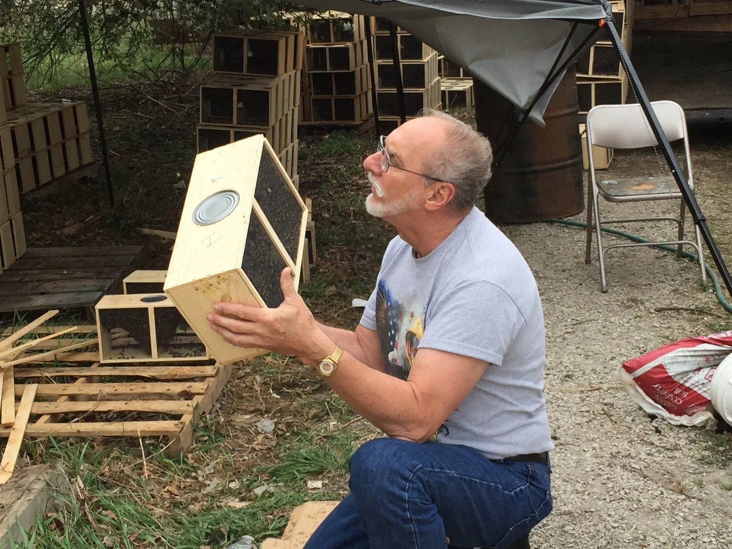 An man holding bee hives.