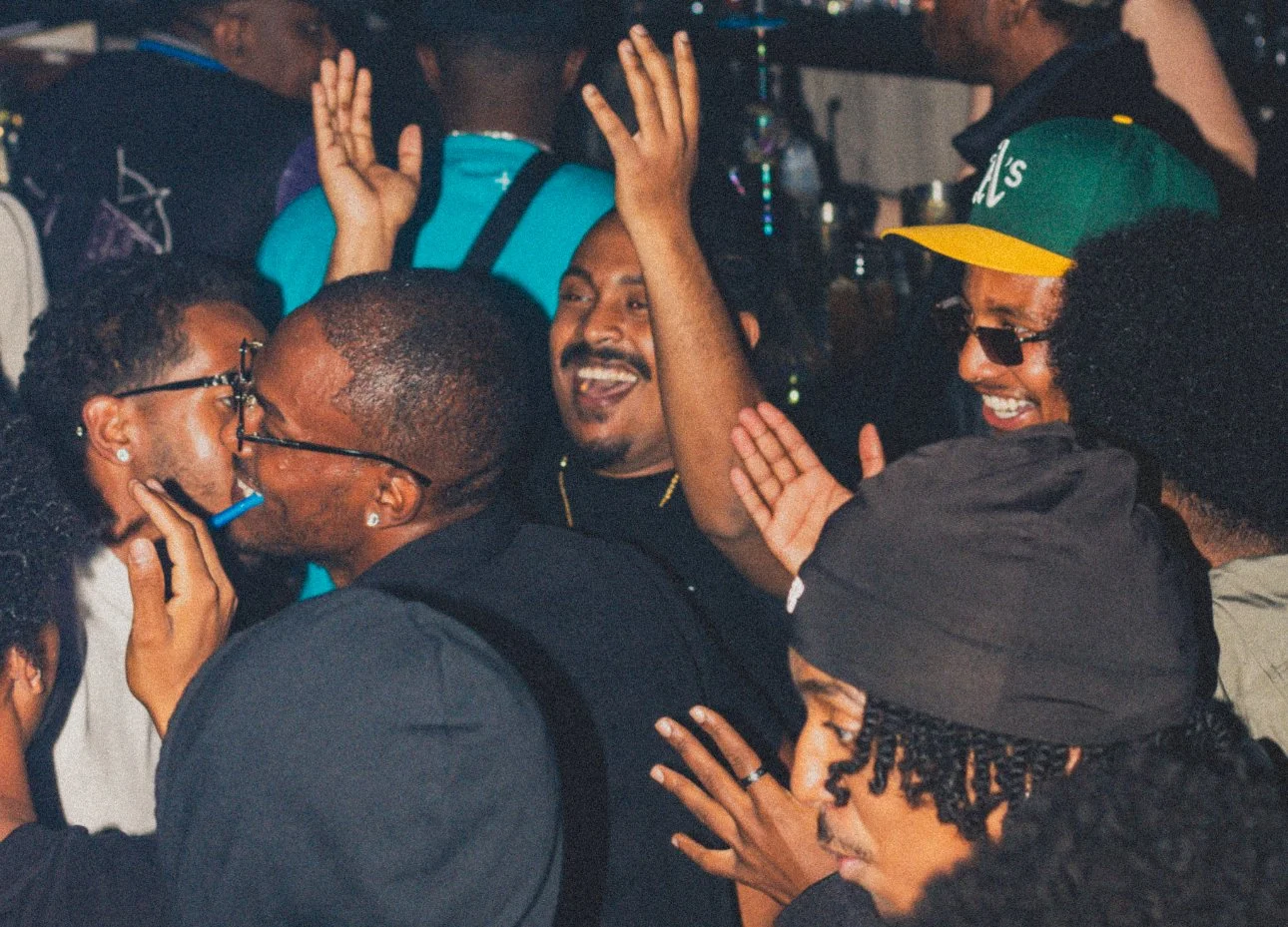Group of people smiling and celebrating together at a social gathering.