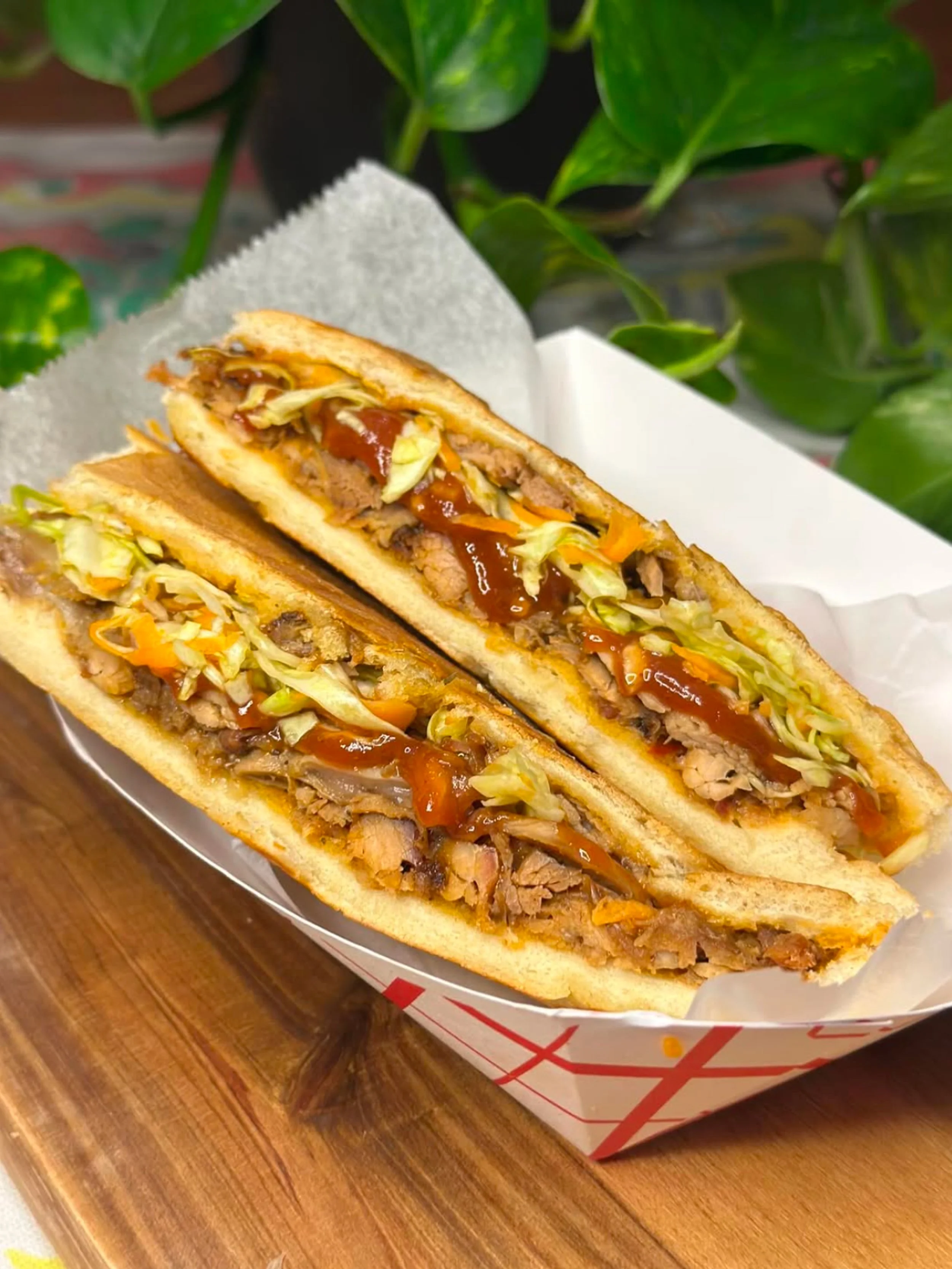 Guava BBQ Pernil Sandwich. Cross-section of a sandwich pressed on French bread, with slow roasted pernil (pork) and house made guava bbq with a pique slaw for some freshness.