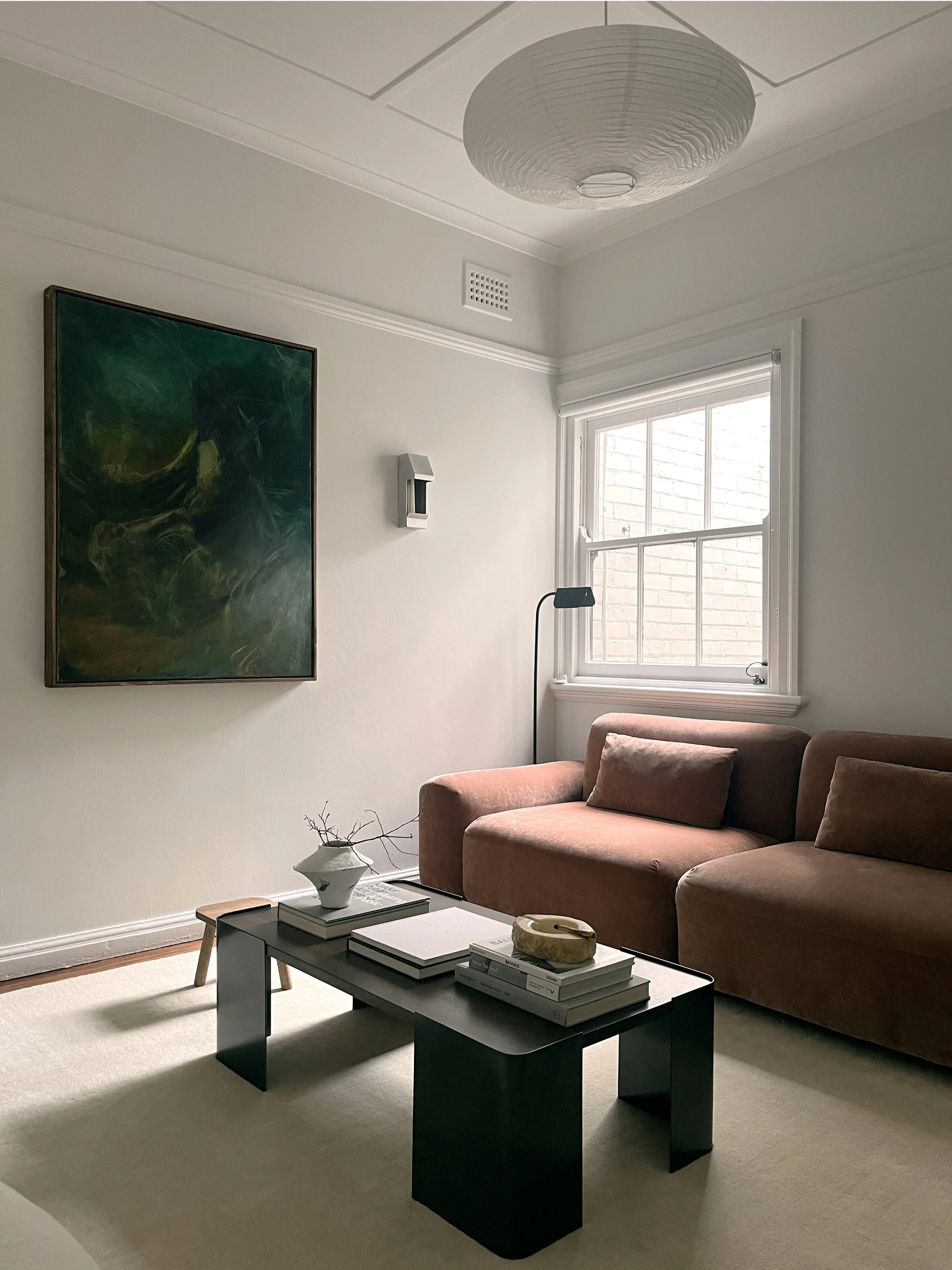 A warm, modern living room with soft light, sculptural furniture, and layered textures. Designed for calm, comfort, and quiet luxury.