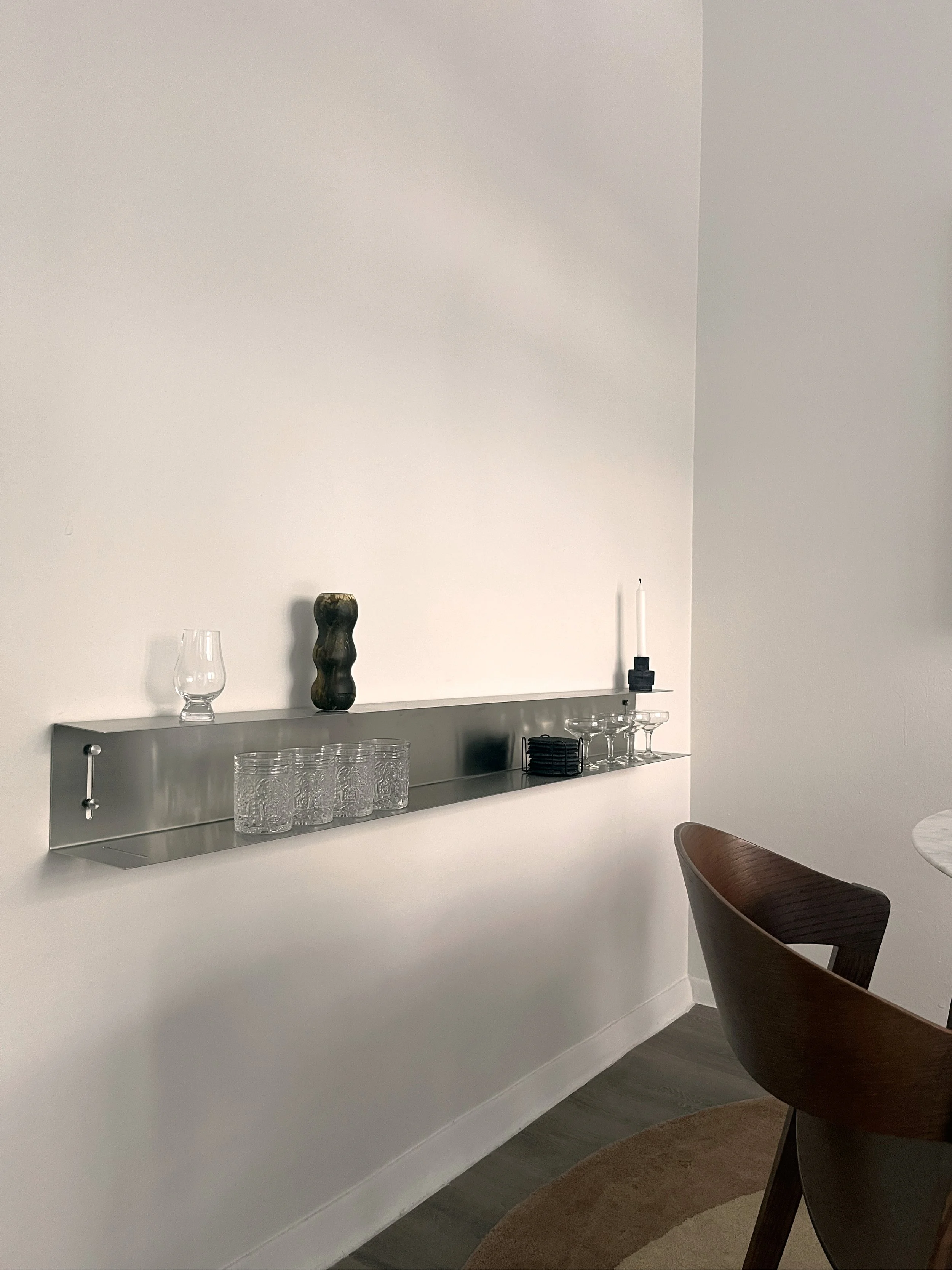 Minimal shelf styling with glassware and sculptural objects, creating a refined and understated interior detail.