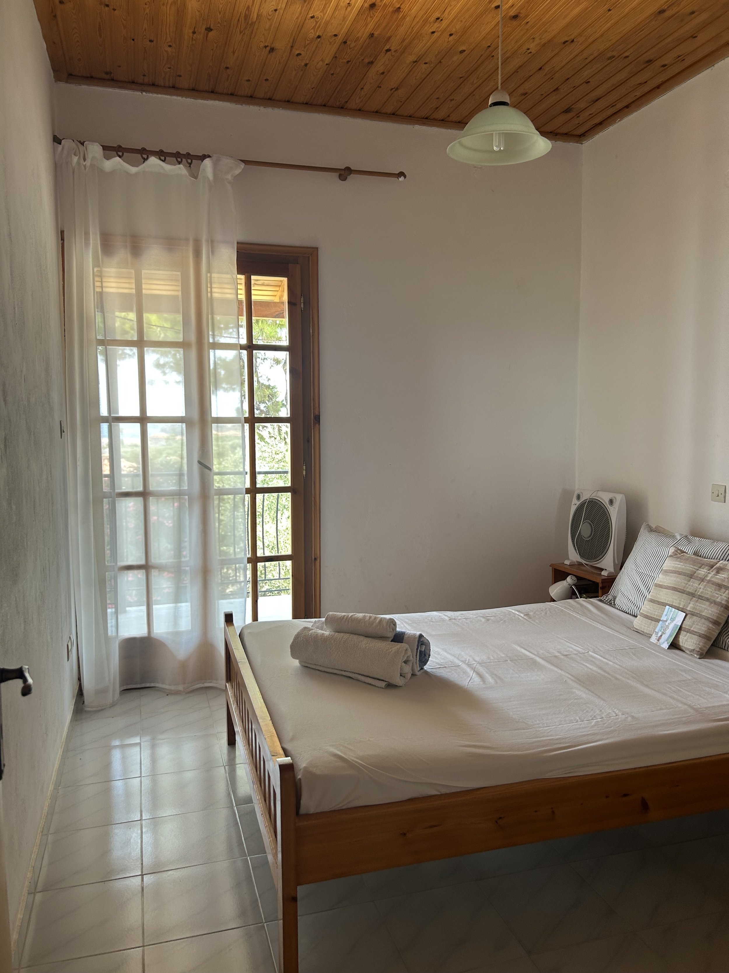 Finikounda Saintfridays holiday apartment Greece – bright whitewashed bedroom with traditional wooden furniture