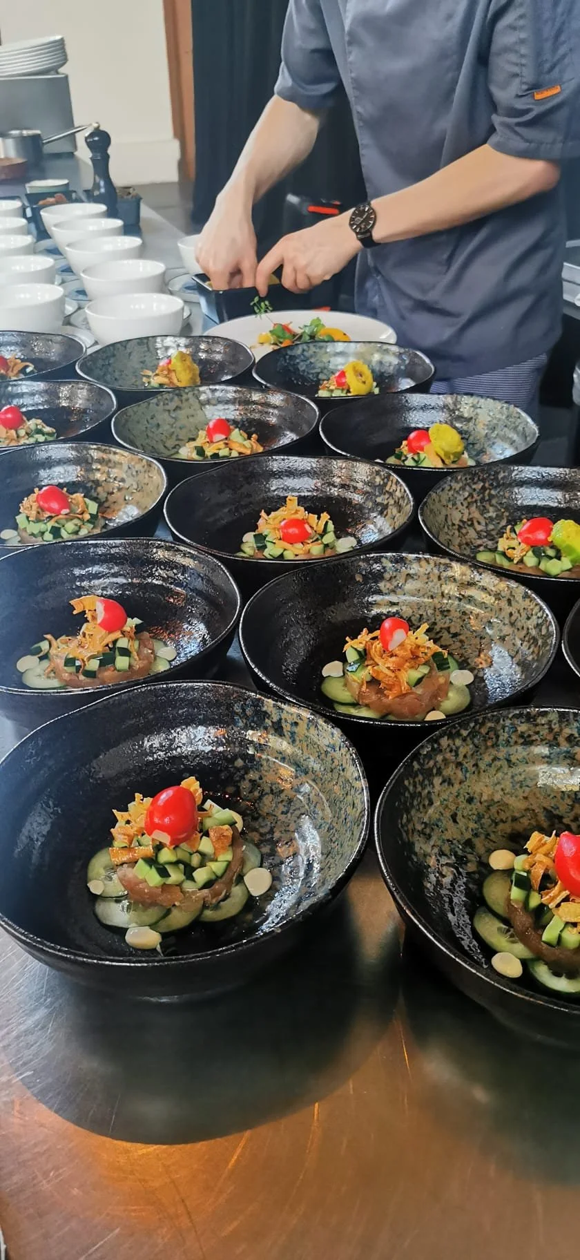 Chef die meerdere gepresenteerde gerechten op borden serveert, met verschillende toppings en versieringen.
