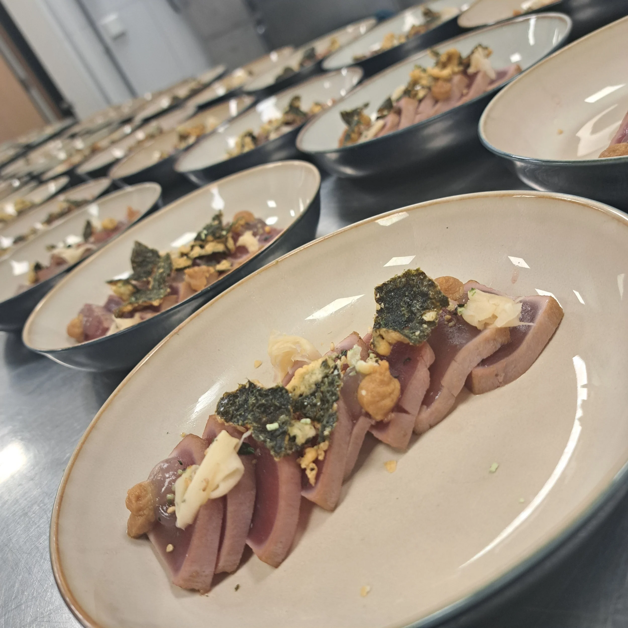 platte met vier stukjes ham, bestrooid met croutons, kaas en kruiden.