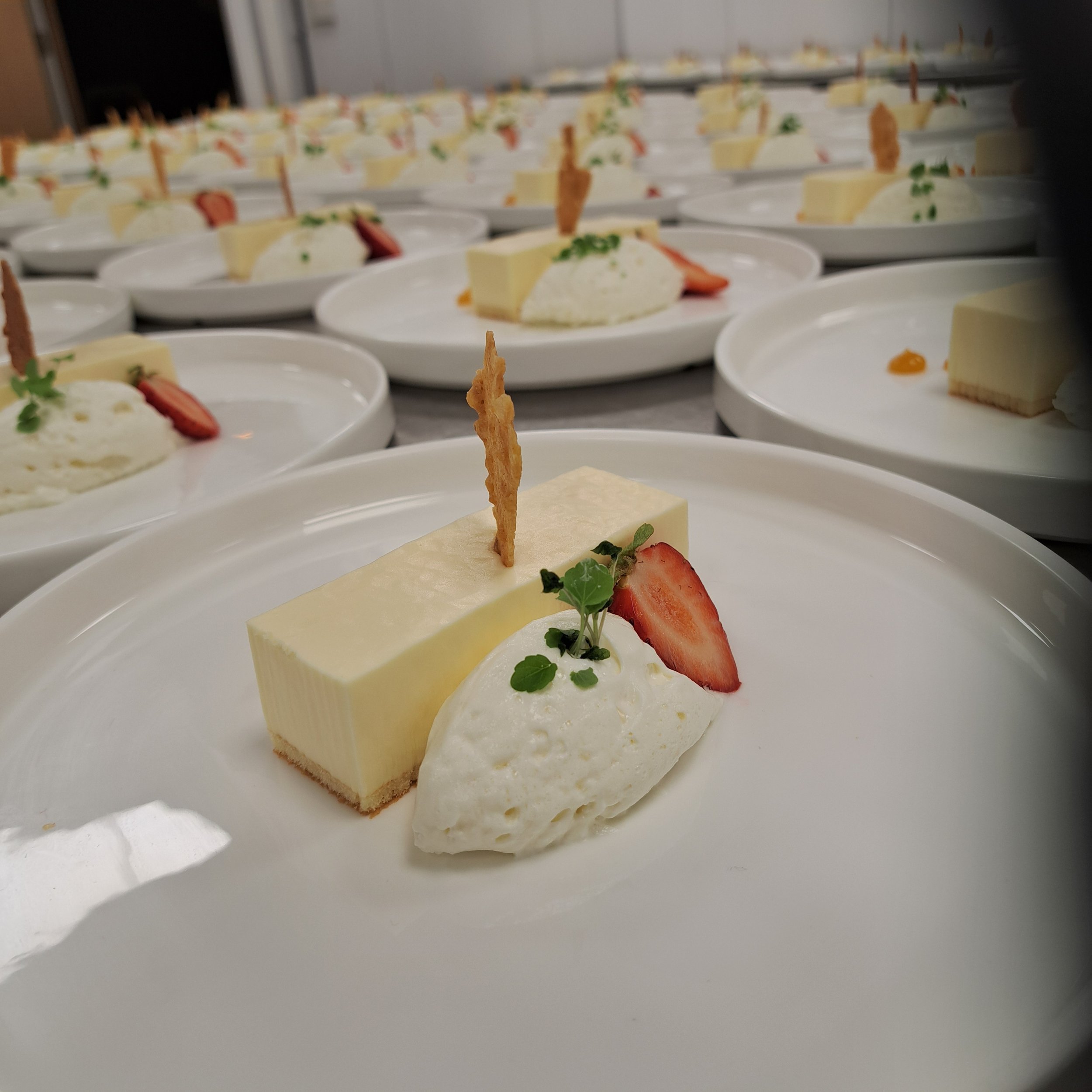Desserts van marscarpone met witte chocolade mousse, aardbeien, atsina en een krokant koekje.