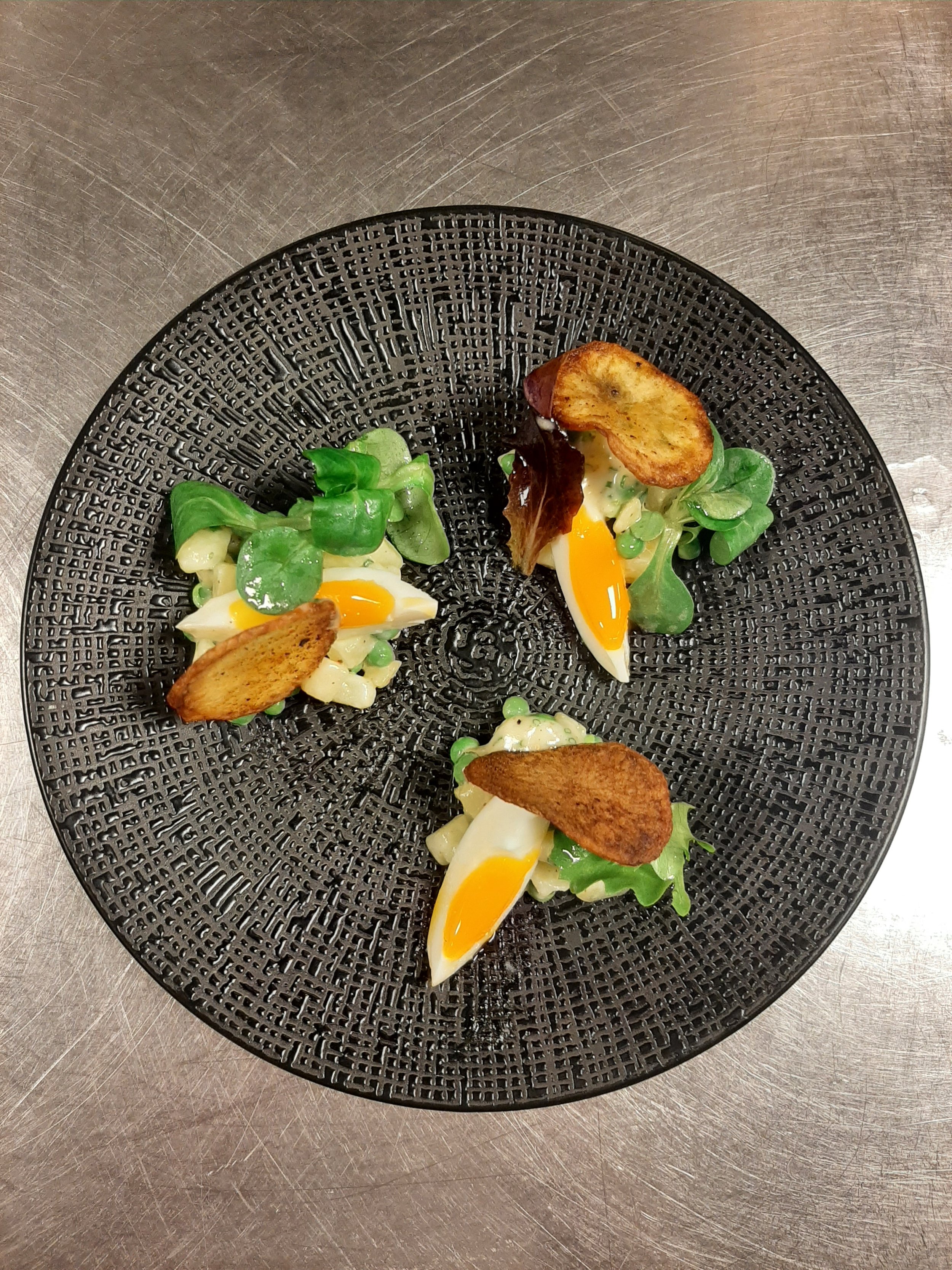 Aardappel en erwten salade, bieslook mayonaisse, mesclun, franse viniagrette, gekookte ui, en aardappel chips.